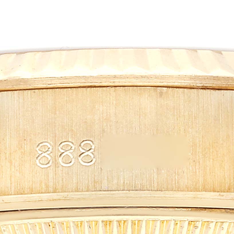 This close-up image shows the side of a Rolex President 69178 Women's Yellow Gold Champagne Dial 69178 Women's Yellow Gold Champagne Dial watch, focusing on stamped engraving and part of the bezel.