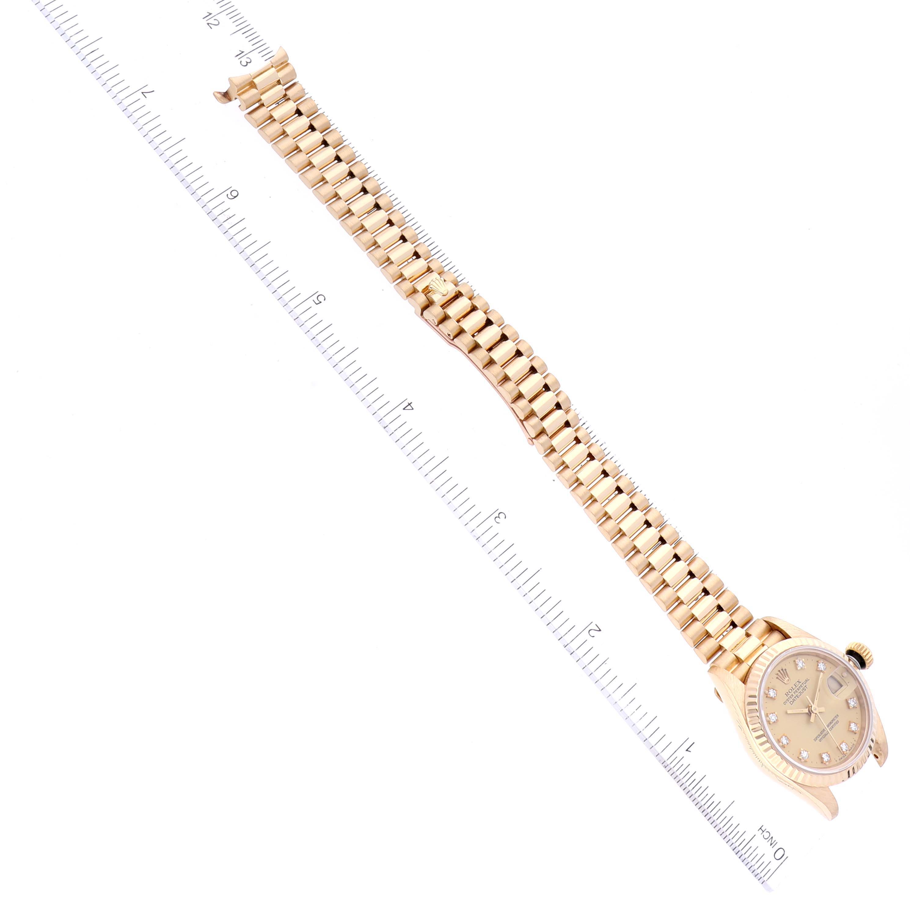 The image shows a Rolex President 69178 Women's Yellow Gold Champagne Dial 69178 Women's Yellow Gold Champagne Dial model watch laid flat, clearly displaying the watch face and bracelet alongside a measuring ruler.