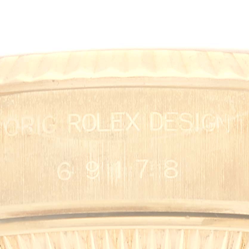 The image shows the side of a Rolex President 69178 Women's Yellow Gold Champagne Dial 69178 Women's Yellow Gold Champagne Dial model watch, focusing on the engraved text on the case side.