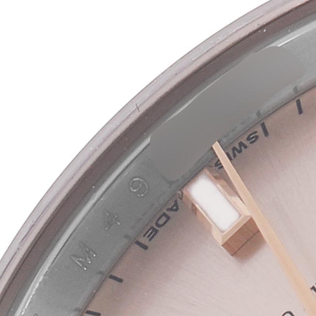 The image shows a close-up of the Rolex Datejust 179171 Men
s Steel and Gold (two tone) Pink Dial 179171 Men
s Steel and Gold (two tone) Pink Dial dial, highlighting a portion of the bezel, hour markers, and the edge.
