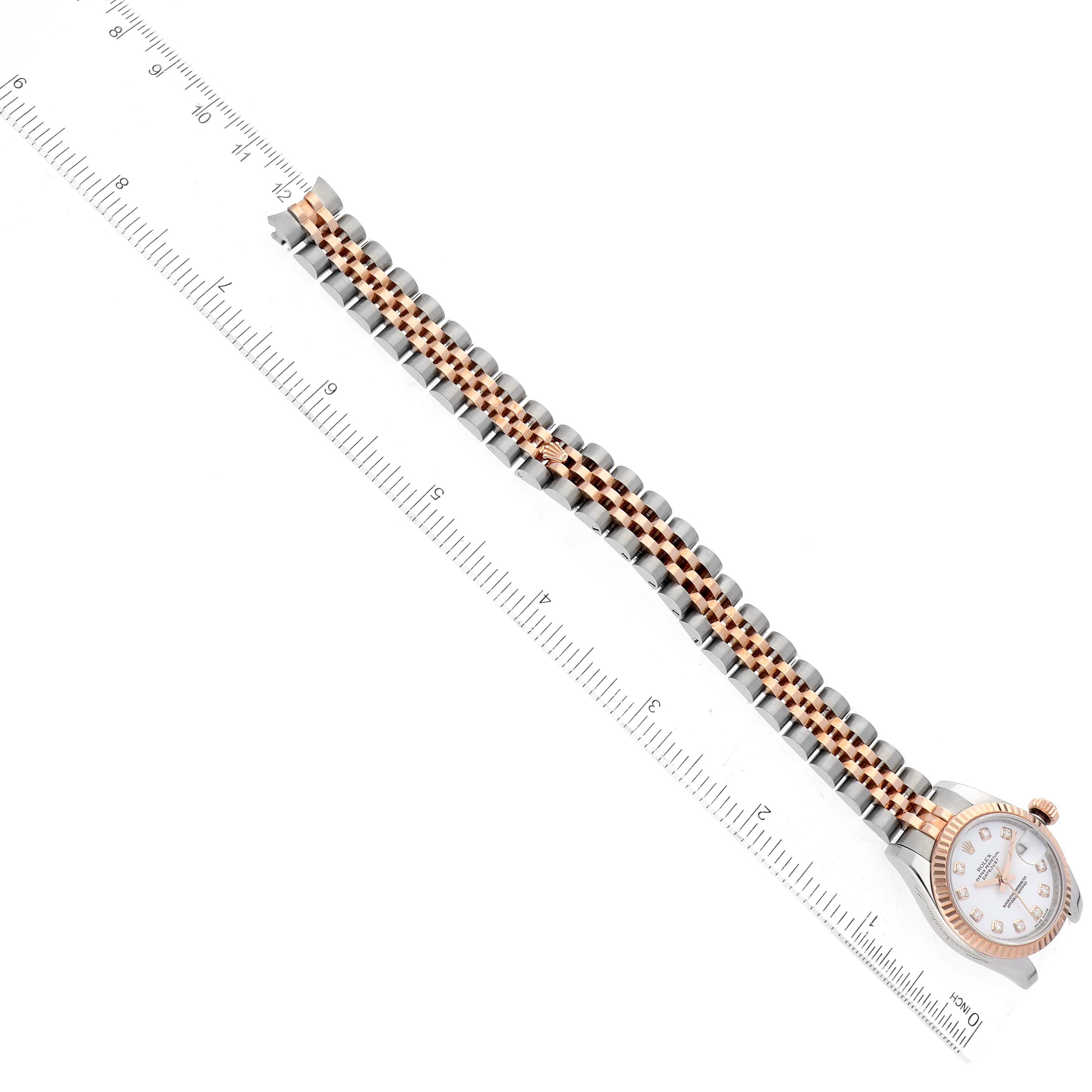 The image shows a Rolex Datejust 179171 Women's Steel and Gold (two tone) White Dial 179171 Women's Steel and Gold (two tone) White Dial watch from an overhead angle, highlighting its face, bezel, and bracelet beside a ruler for scale.