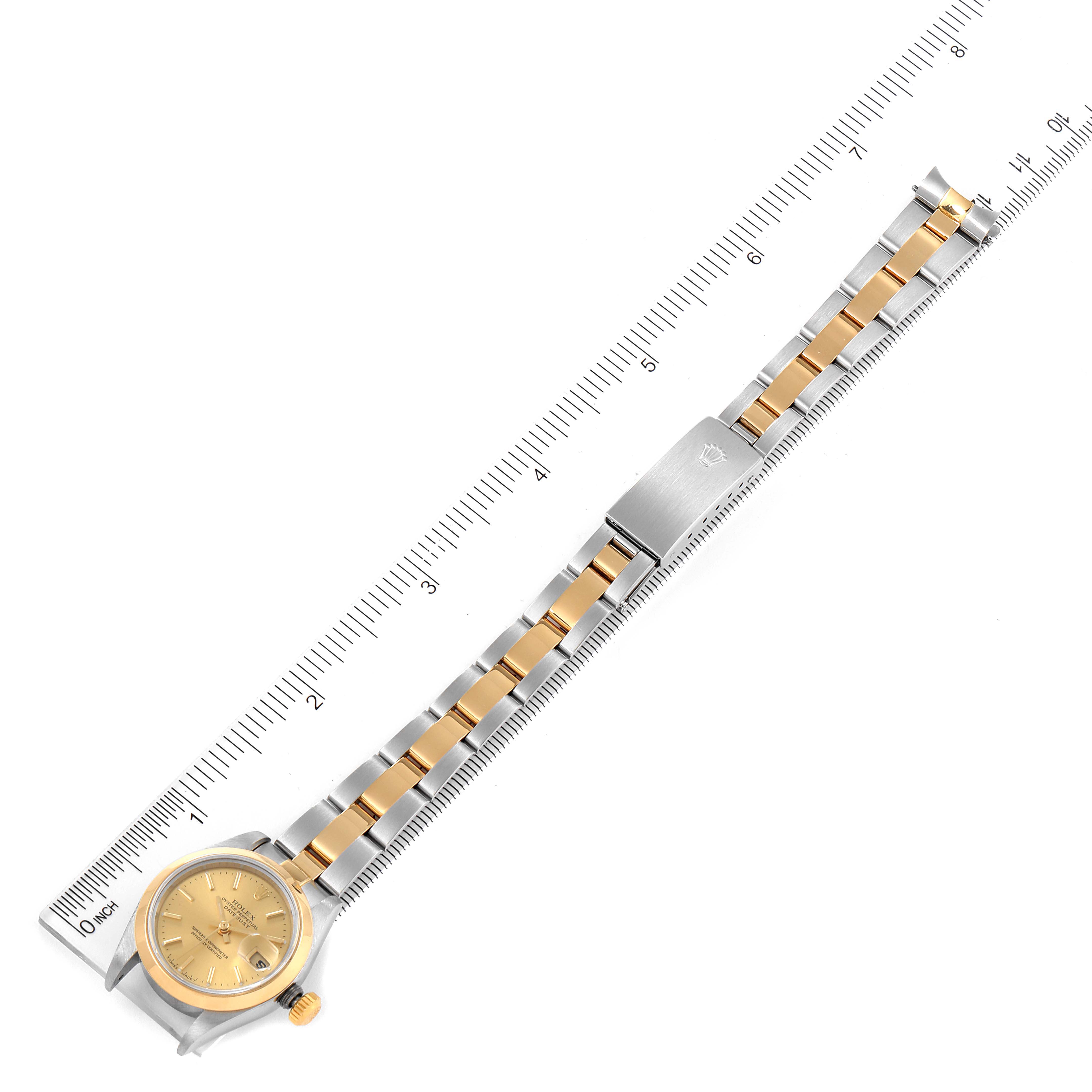 The image shows the entire Rolex Datejust 79163 Women's Steel and Gold (two tone) Champagne Dial 79163 Women's Steel and Gold (two tone) Champagne Dial watch laying flat with its front dial, bracelet, and clasp visible next to a ruler.