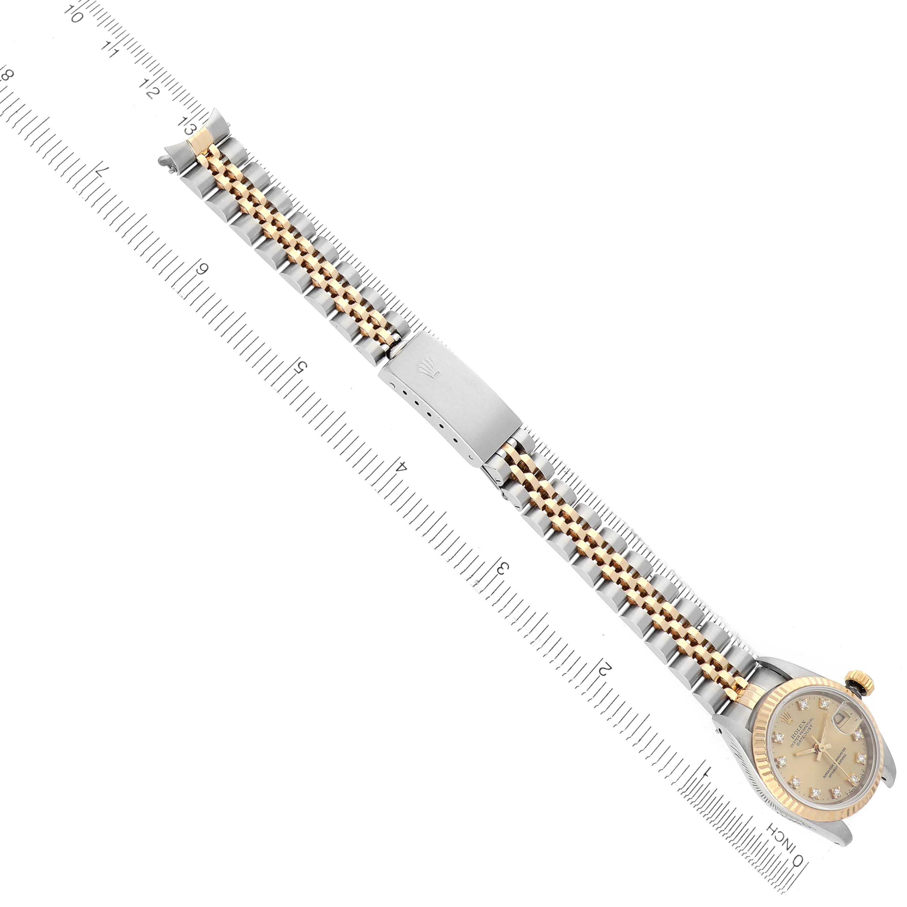The Rolex Datejust 69173 Women's Steel and Gold (two tone) Champagne Dial 69173 Women's Steel and Gold (two tone) Champagne Dial is shown from a top-down angle displaying the face, bezel, and full bracelet alongside a ruler.