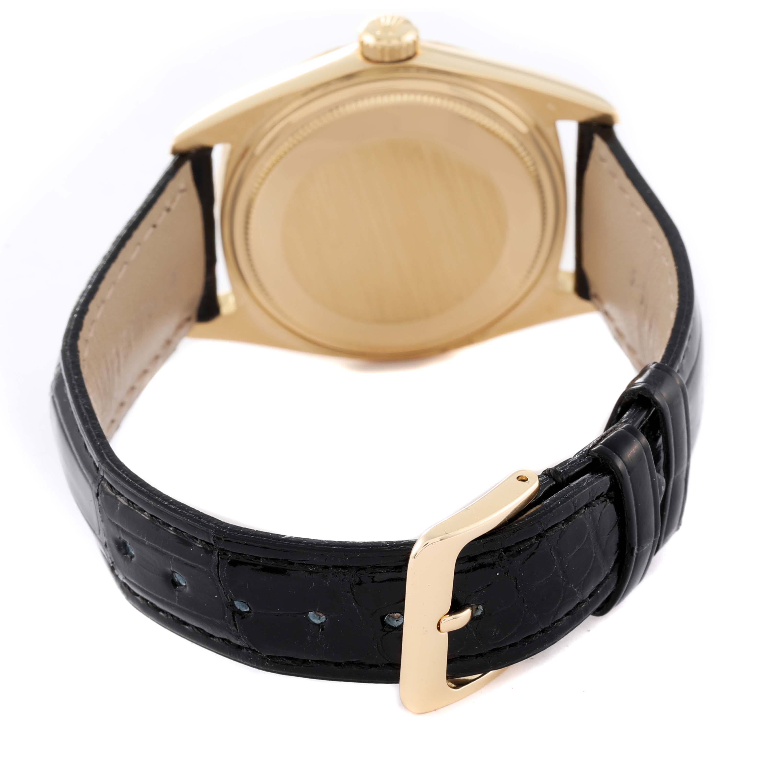 The image shows the back view of a Rolex Vintage Collection 1607 Men's Yellow Gold Champagne Dial 1607 Men's Yellow Gold Champagne Dial watch, highlighting its gold case and black leather strap with a gold buckle.