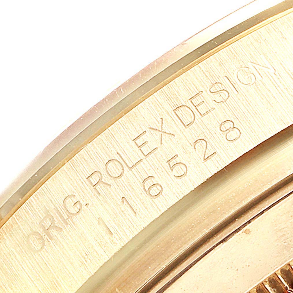 The image shows a close-up of the side of a Rolex Daytona 116528 Men's Yellow Gold White Dial 116528 Men's Yellow Gold White Dial watch, highlighting the engraved design and model number.