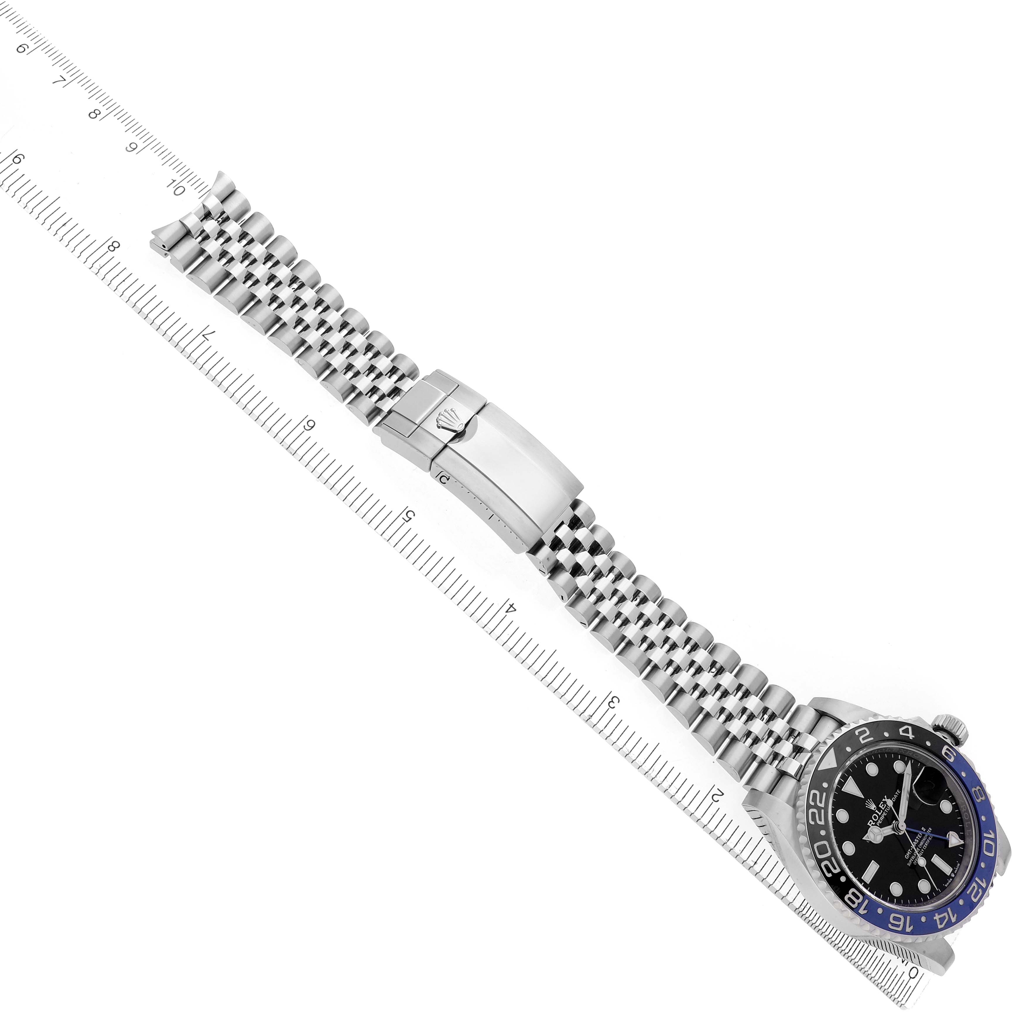 The image shows a Rolex GMT-Master 126710 Men's Stainless Steel Black Dial 126710 Men's Stainless Steel Black Dial watch with a jubilee bracelet laid flat alongside a ruler, highlighting the clasp and face.