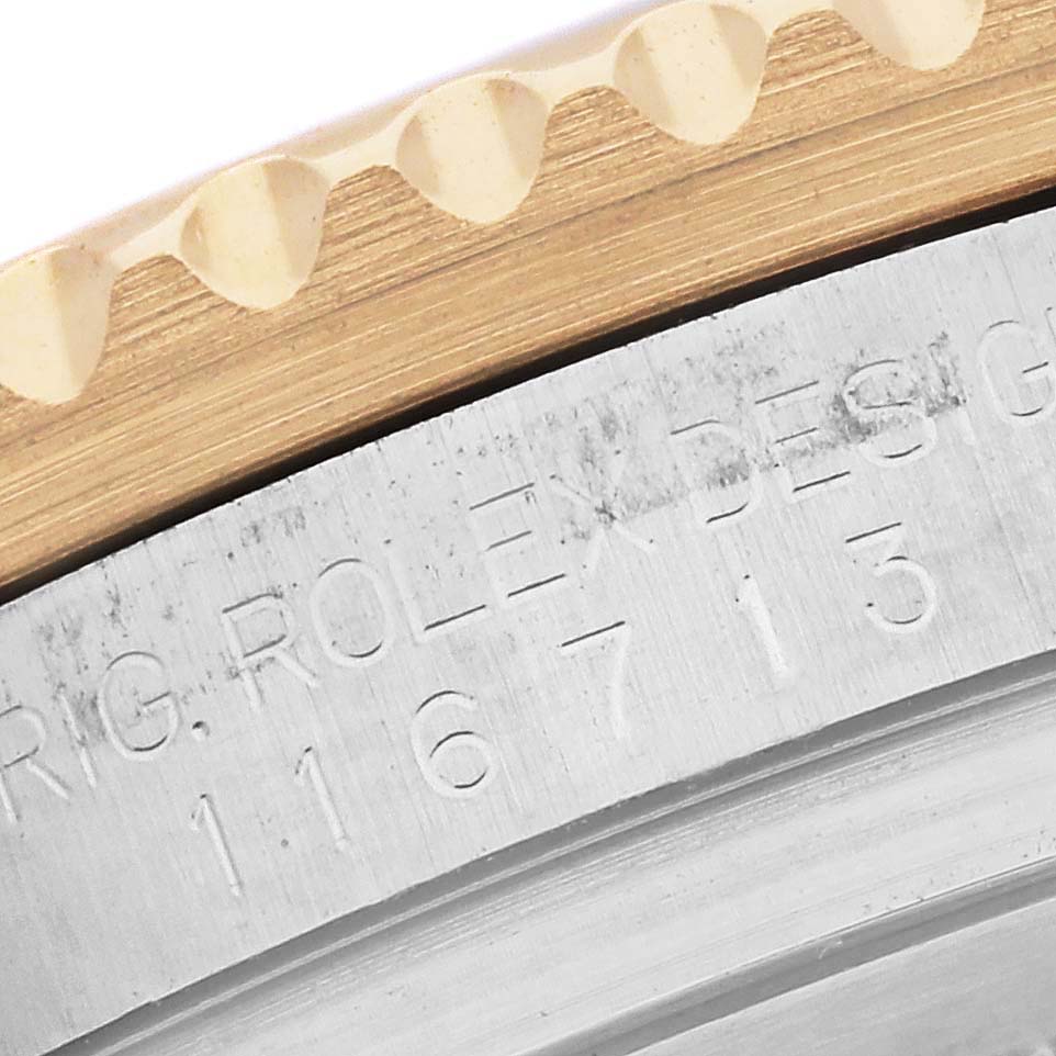 The image shows a close-up of the bezel edge and the engraved details on the casing of a Rolex GMT-Master 116713 Men's Steel and Gold (two tone) Black Dial 116713 Men's Steel and Gold (two tone) Black Dial watch.