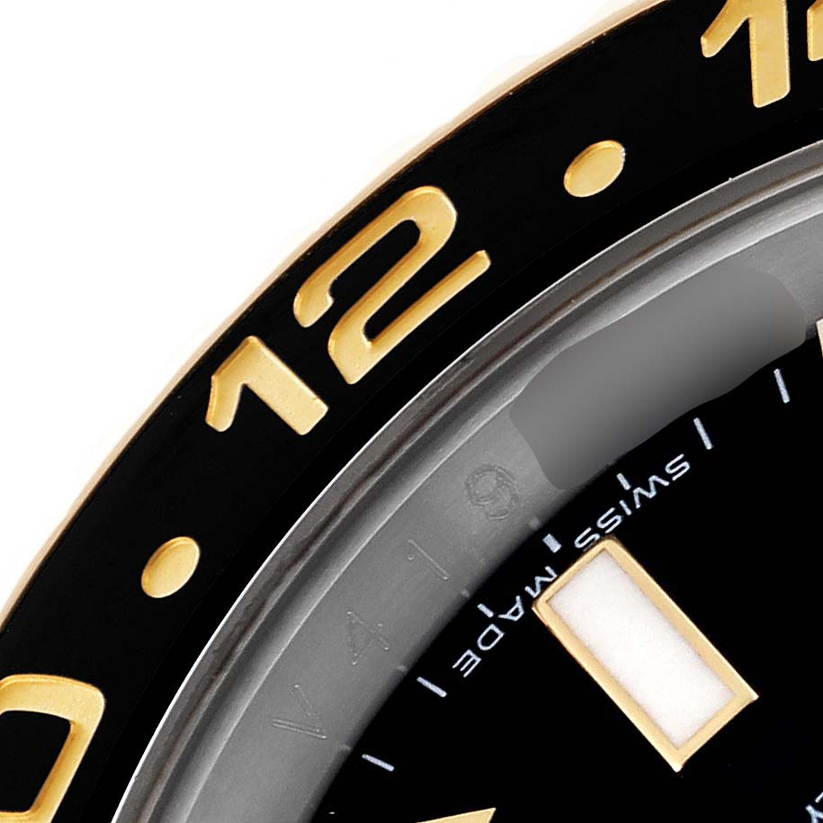 The image shows a close-up of the bezel and part of the dial of a Rolex GMT-Master 116713 Men's Steel and Gold (two tone) Black Dial 116713 Men's Steel and Gold (two tone) Black Dial watch, focusing on the numeral "12" and a portion of the "Swiss Made" text.