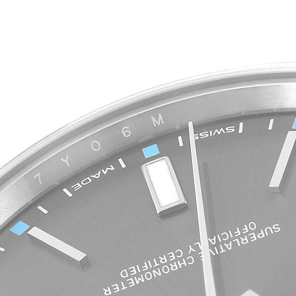 This image shows a close-up of the dial and bezel of a Rolex Oyster Perpetual 114300 Men's Stainless Steel Grey Dial 114300 Men's Stainless Steel Grey Dial watch, featuring markers and part of the second hand.