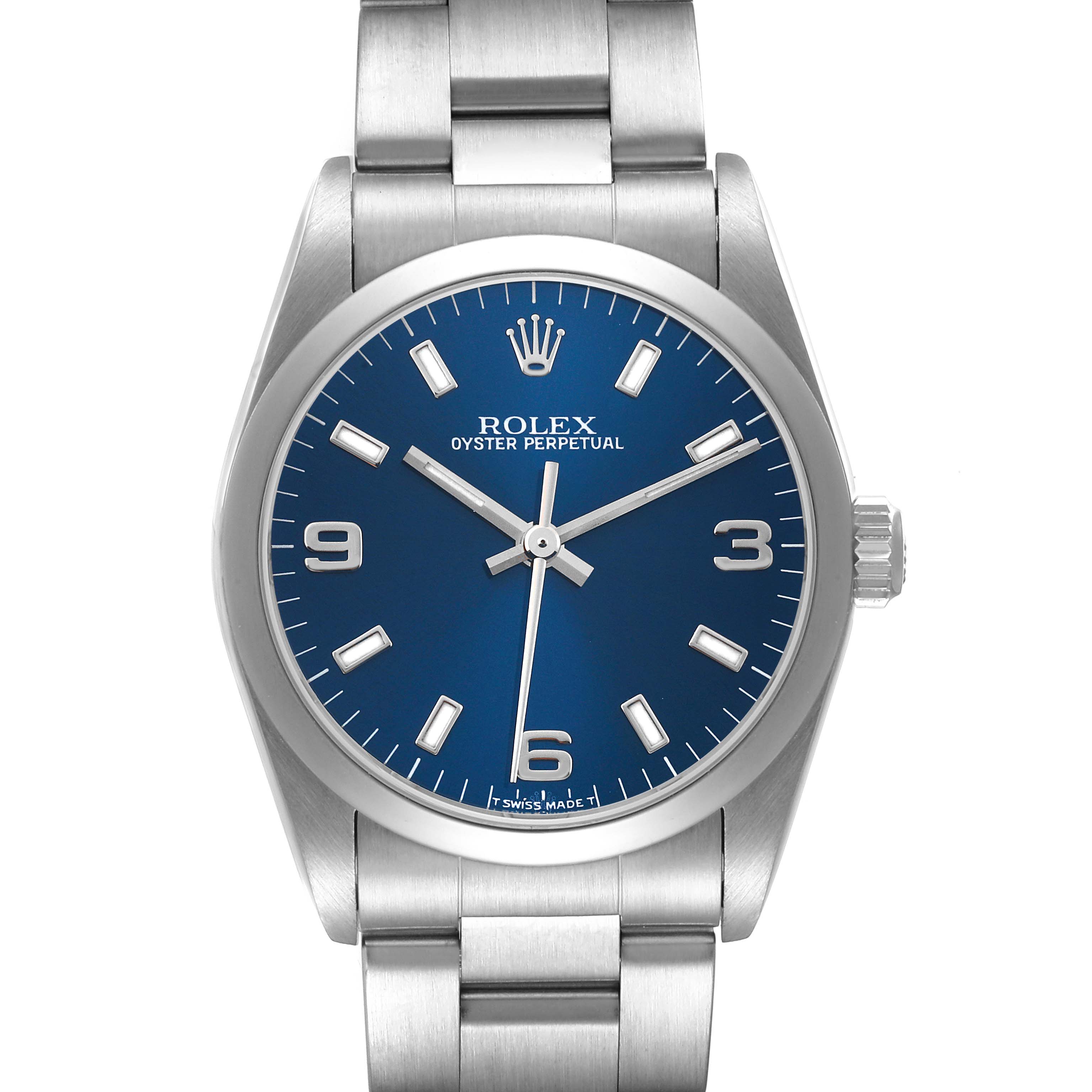 The image shows a Rolex Mid-Size 77080 Women
s Stainless Steel Blue Dial 77080 Women
s Stainless Steel Blue Dial Oyster Perpetual watch with a blue dial, silver hands, and a stainless steel bracelet, viewed from the front.