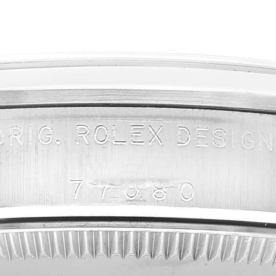 The image shows the side view of a Rolex Mid-Size 77080 Women
s Stainless Steel Blue Dial 77080 Women
s Stainless Steel Blue Dial watch with the engraving "ORIG. ROLEX DESIGN" and the model number "77080".