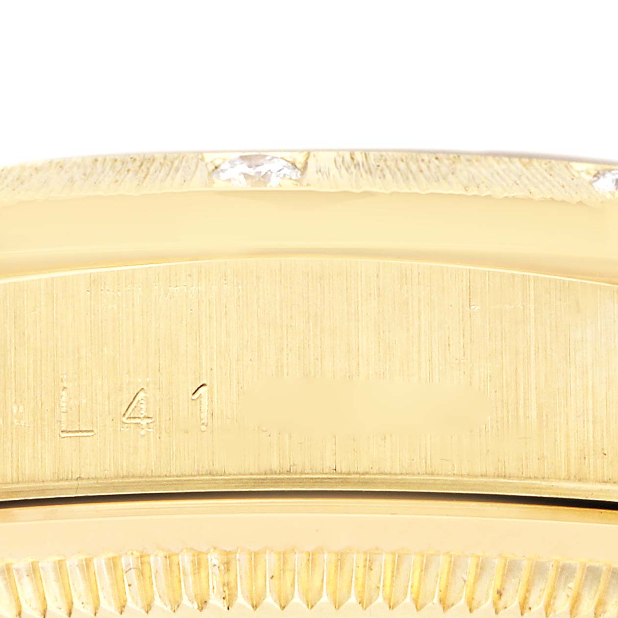 The image shows a close-up of the side of a Rolex President 18308 Men
s Yellow Gold Champagne Dial 18308 Men
s Yellow Gold Champagne Dial watch, focusing on its gold case with visible engravings.