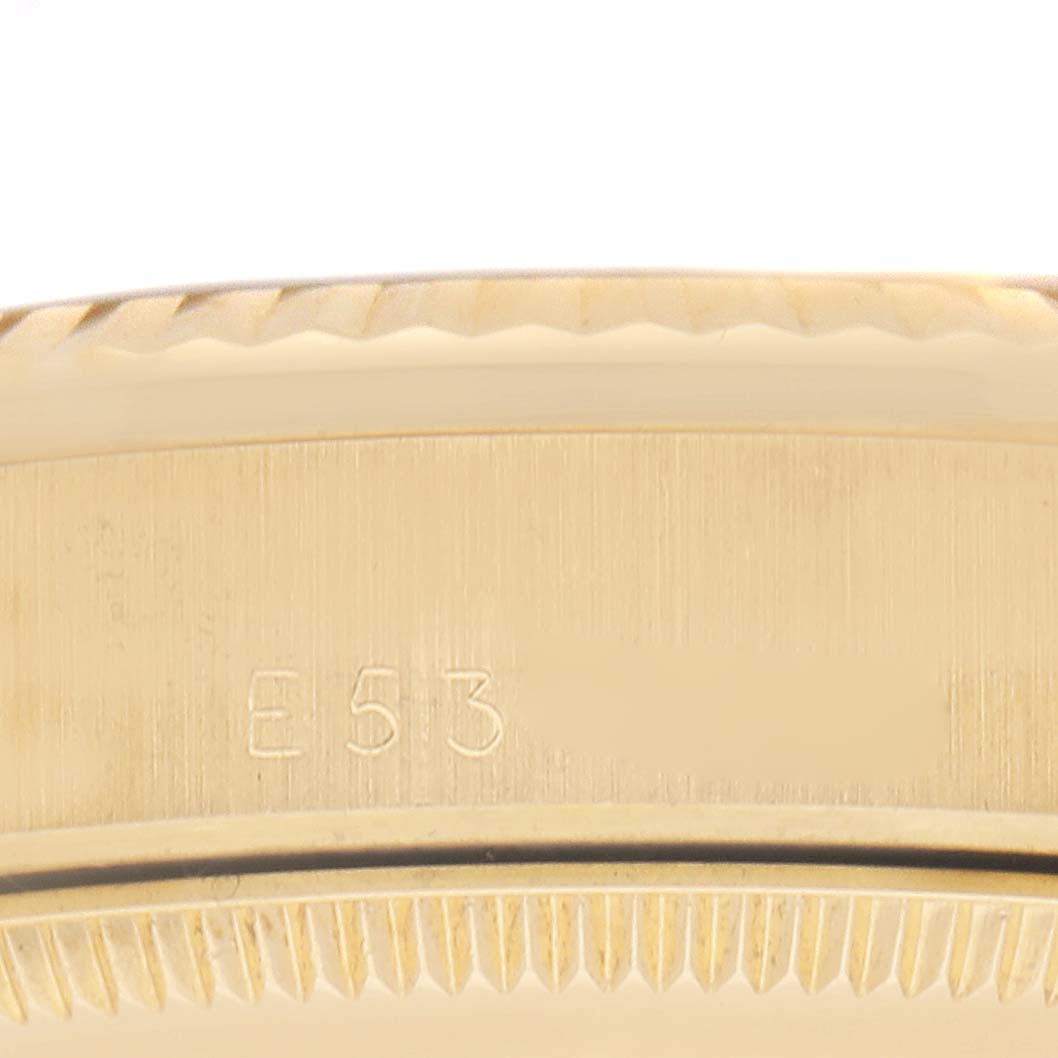 The image shows a close-up of the side of a gold Rolex Mid-Size watch, highlighting the engraved edge and part of the serial number.