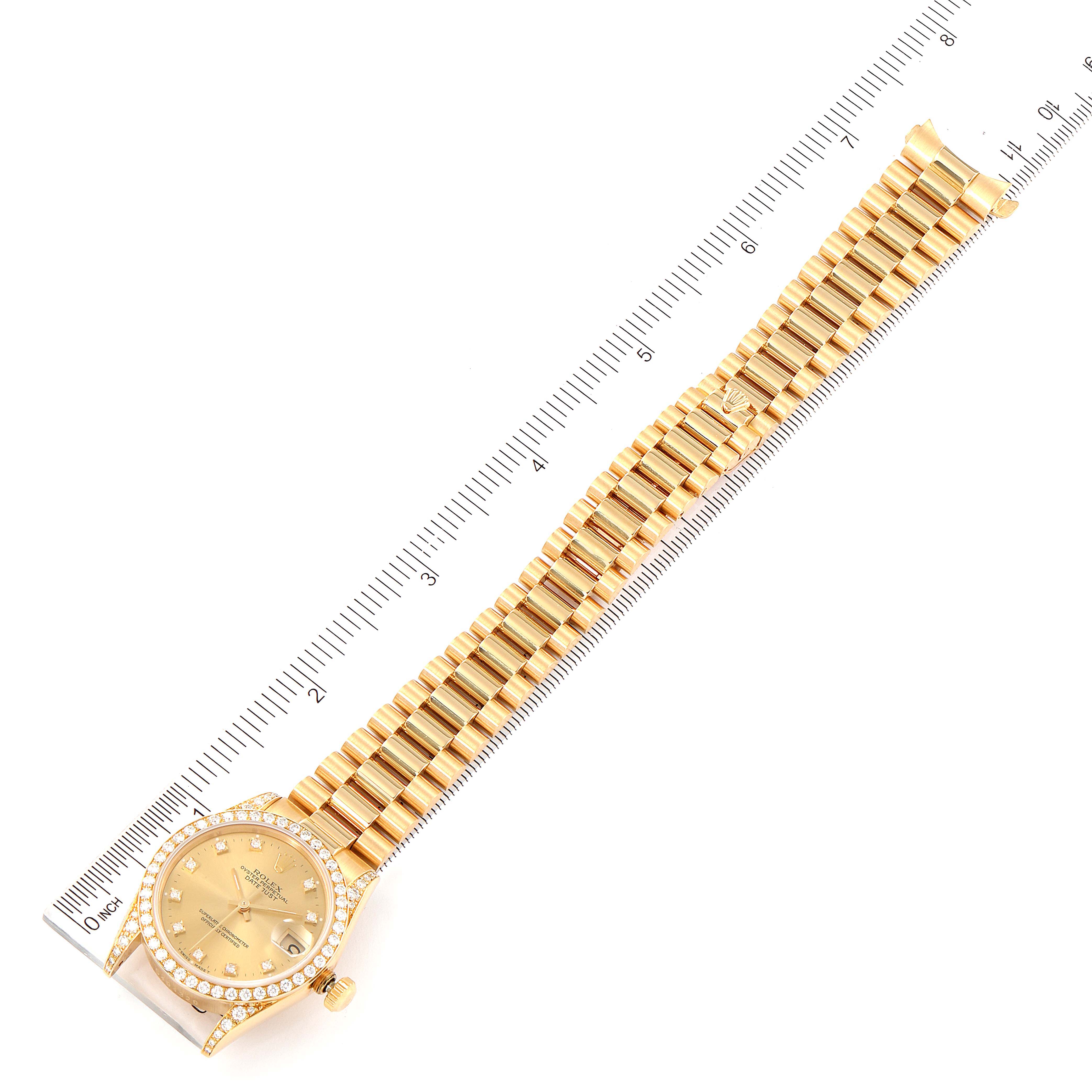 This image shows a top-down view of a Rolex President 68158 Women
s Yellow Gold Champagne Dial 68158 Women
s Yellow Gold Champagne Dial model watch with a gold band next to a ruler.