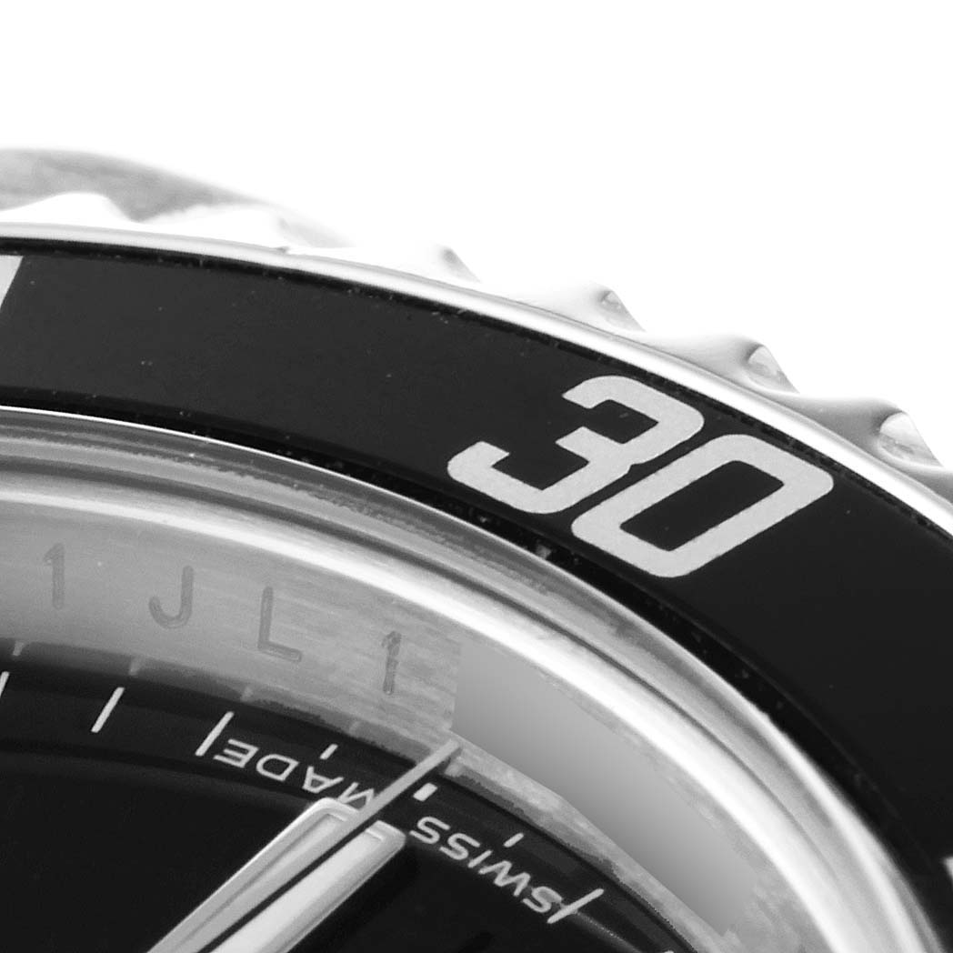 The image shows a close-up of the bezel and a portion of the dial of a Rolex Submariner 14060M Men
s Stainless Steel Black Dial 14060M Men
s Stainless Steel Black Dial watch with the "30" minute marker visible.