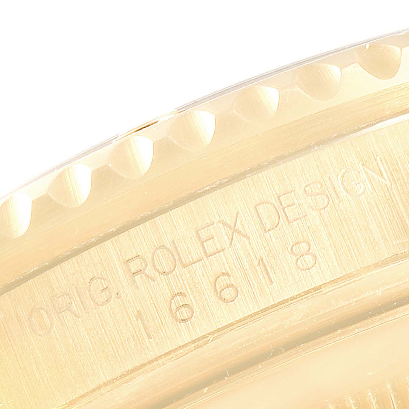 Close-up of the side view of a Rolex Submariner 16618 Men's Yellow Gold Grey Dial 16618 Men's Yellow Gold Grey Dial, focusing on the bezel and engraved model details.