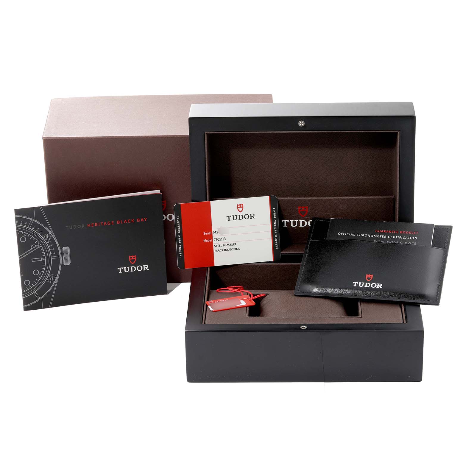 This image shows the open packaging of the Tudor Heritage Black Bay 79220R Men
s Stainless Steel Black Dial 79220R Men
s Stainless Steel Black Dial watch, including the box, manuals, and warranty cards.