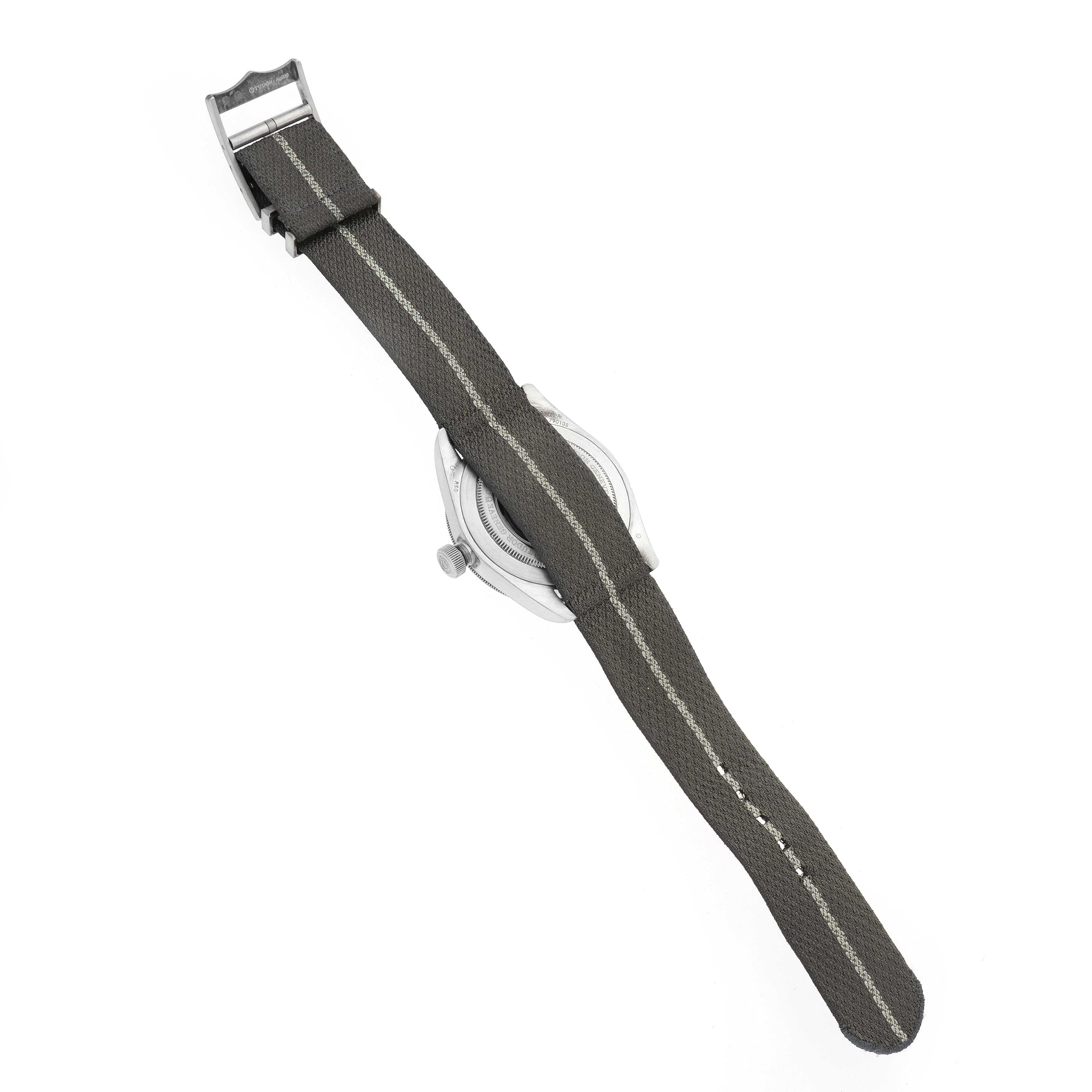 The image shows the back view of a Tudor Heritage Black Bay 79010 Men
s Stainless Steel Grey Dial 79010 Men
s Stainless Steel Grey Dial watch with a fabric strap and visible buckle.