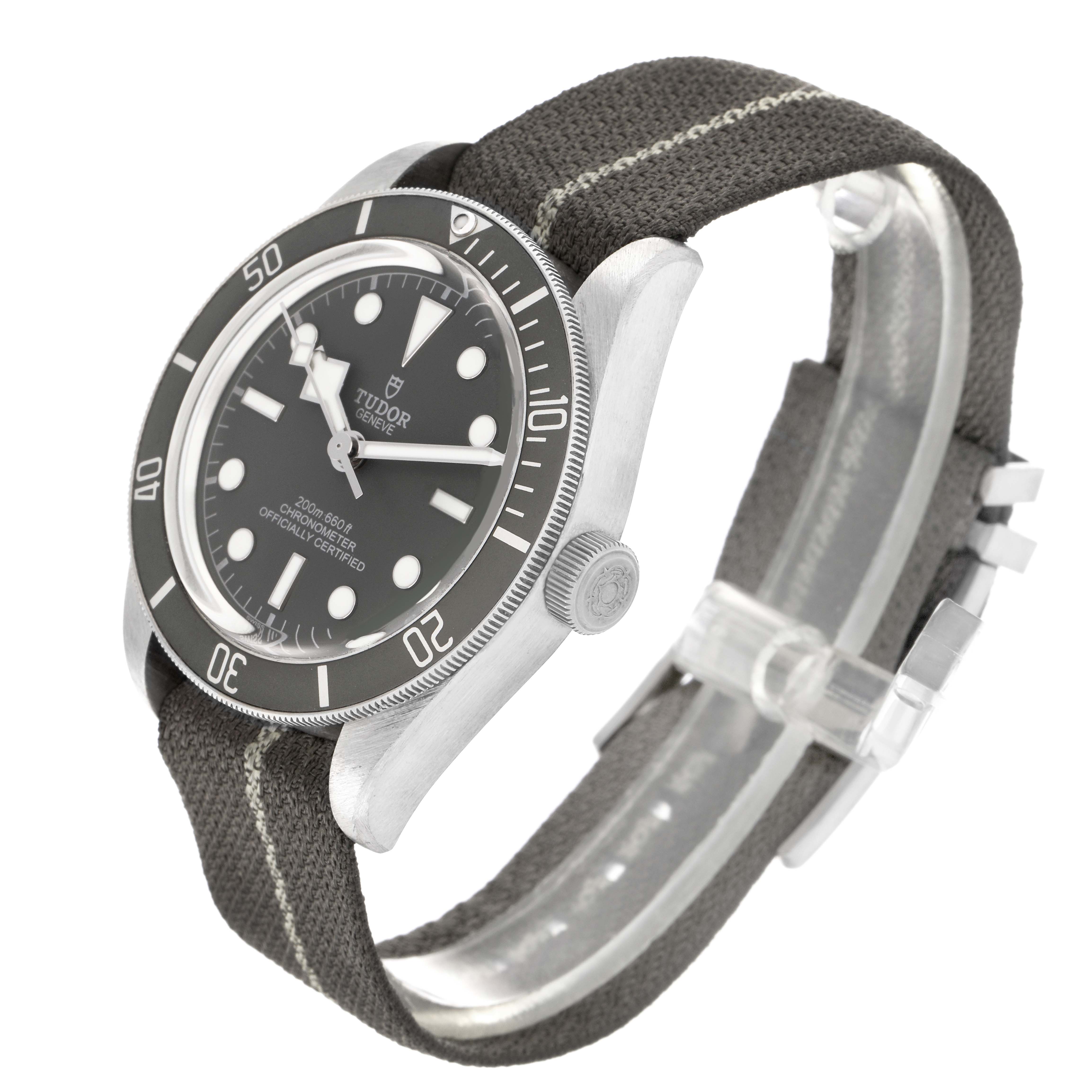 The Tudor Heritage Black Bay 79010 Men
s Stainless Steel Grey Dial 79010 Men
s Stainless Steel Grey Dial watch is shown at a side angle, highlighting the dial, bezel, crown, and fabric strap.