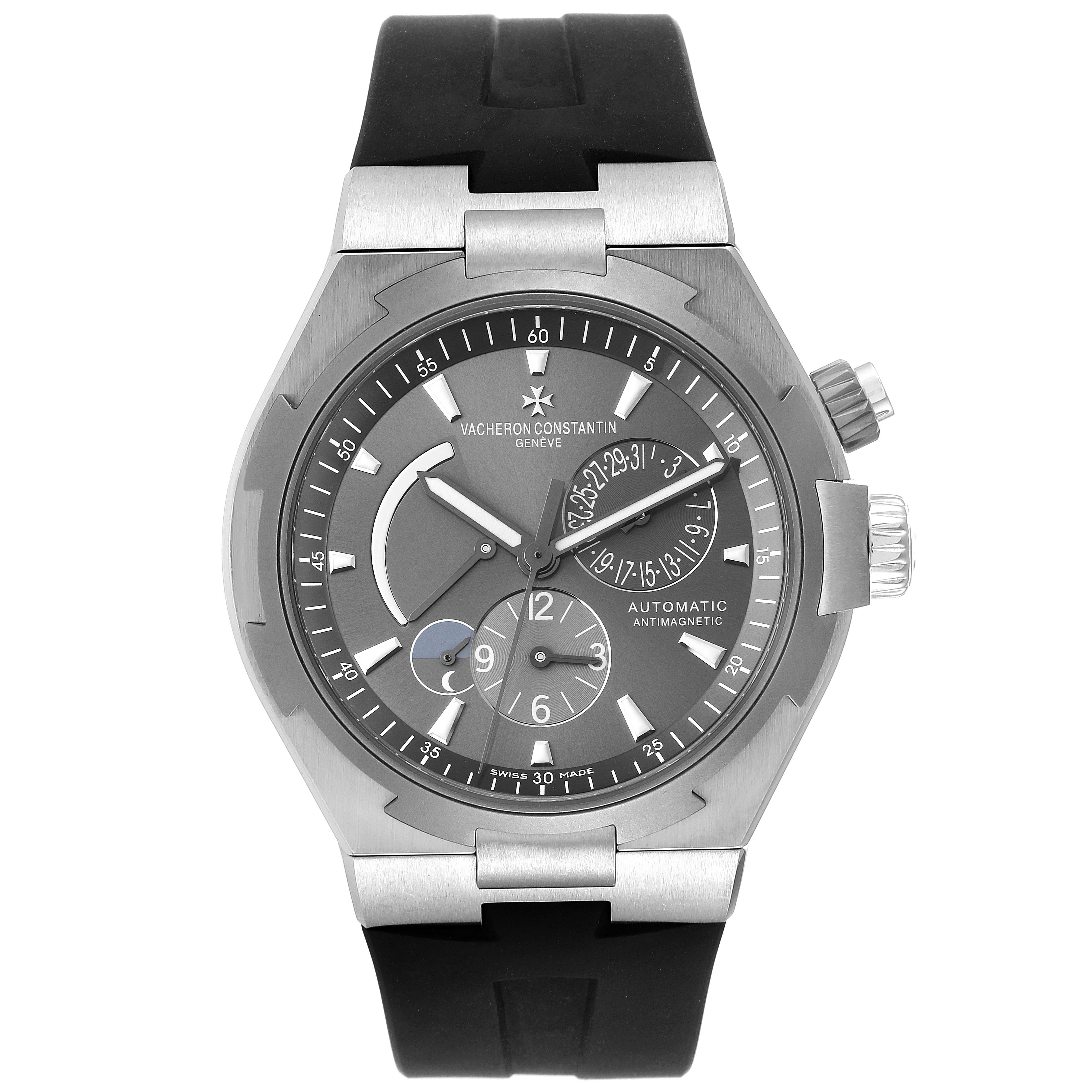 The image shows a Vacheron Constantin Overseas 47450/000W-9511 Men's Stainless Steel Grey Dial 47450/000W-9511 Men's Stainless Steel Grey Dial model watch from the front, displaying its dial, hands, sub-dials, and black strap.
