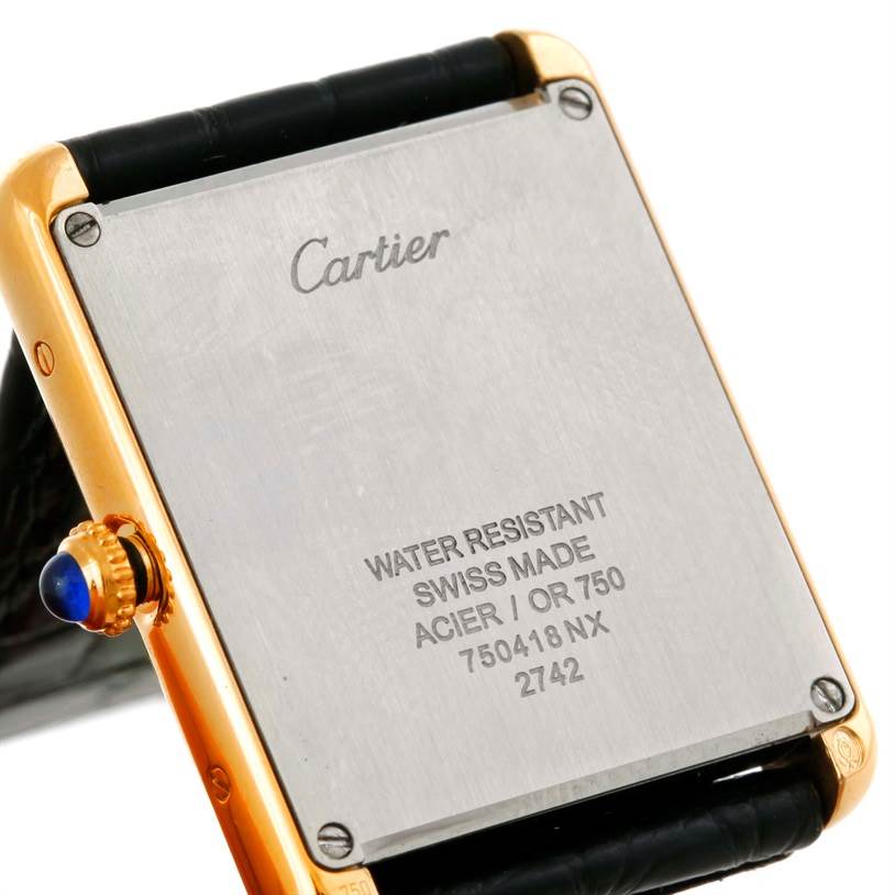 The image shows the back case of a Cartier Tank Solo W1018855 Men
s Steel and Gold (two tone) Silver Dial W1018855 Men
s Steel and Gold (two tone) Silver Dial watch, highlighting the inscriptions and crown.