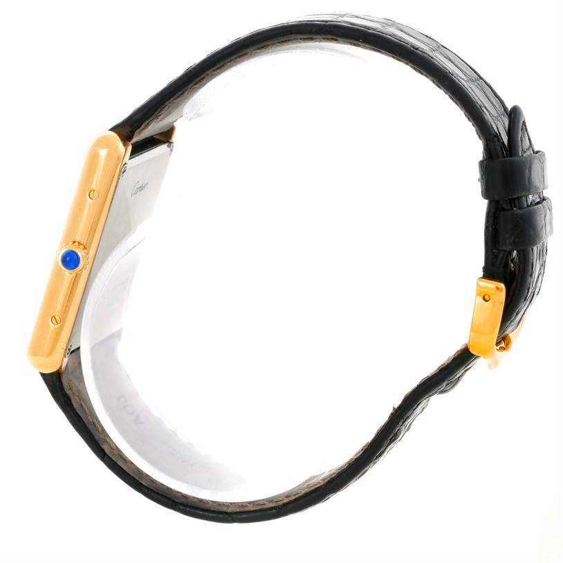 The image shows a side view of a Cartier Tank Solo W1018855 Men
s Steel and Gold (two tone) Silver Dial W1018855 Men
s Steel and Gold (two tone) Silver Dial watch, highlighting its gold case, blue cabochon crown, and black leather strap.