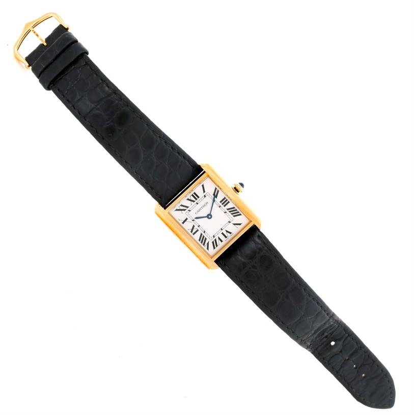 The Cartier Tank Solo W1018855 Men
s Steel and Gold (two tone) Silver Dial W1018855 Men
s Steel and Gold (two tone) Silver Dial watch is shown from a top-down angle, highlighting its rectangular dial, black strap, and gold buckle.