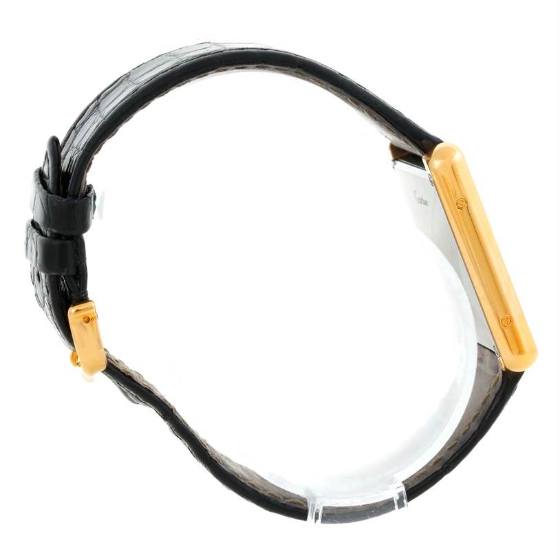 The image shows a Cartier Tank Solo W1018855 Men
s Steel and Gold (two tone) Silver Dial W1018855 Men
s Steel and Gold (two tone) Silver Dial watch from the side, highlighting the strap and the gold case.