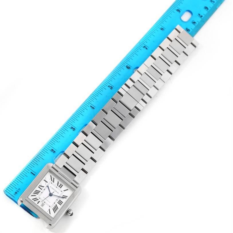 The Cartier Tank Solo W5200028 Men
s Stainless Steel Silver Dial W5200028 Men
s Stainless Steel Silver Dial watch is shown flat with its face and entire metal bracelet visible alongside a blue ruler for measurement.