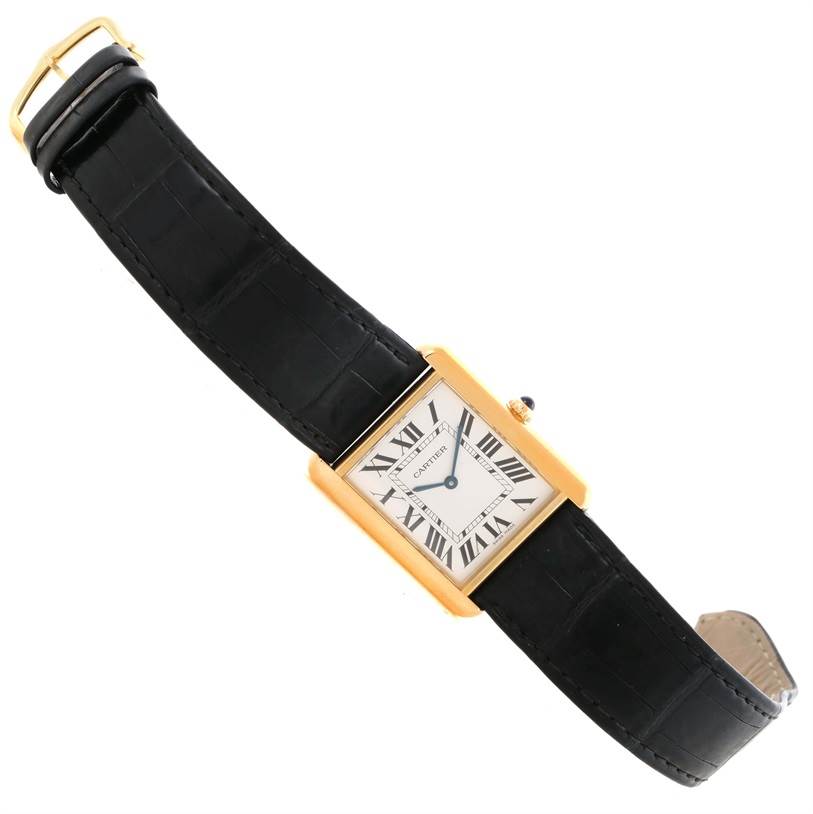 The Cartier Tank Solo W1018855 Men
s Steel and Gold (two tone) Silver Dial W1018855 Men
s Steel and Gold (two tone) Silver Dial watch is shown from an overhead angle, displaying the black strap, rectangular gold case, and dial with Roman numerals.