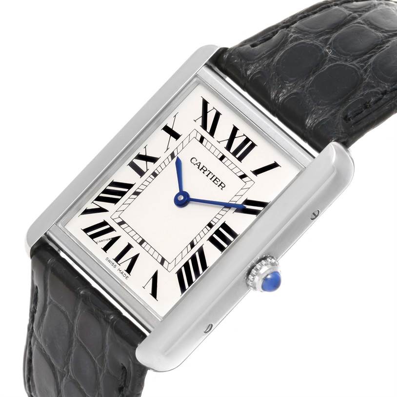 The Cartier Tank Solo W1018355 Stainless Steel Silver Dial W1018355 Stainless Steel Silver Dial watch is shown at an angled view, displaying its Roman numeral dial, blue hands, and black leather strap.
