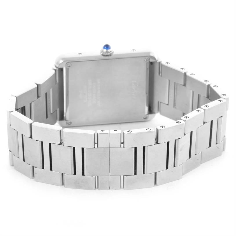 The image shows the back of a Cartier Tank Solo W5200014 Men
s Stainless Steel Silver Dial W5200014 Men
s Stainless Steel Silver Dial watch, highlighting its silver bracelet and caseback with a blue crown jewel.