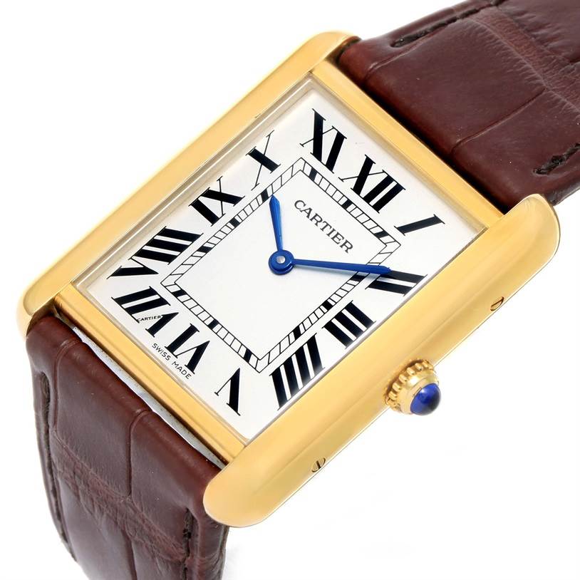 The image shows a close-up, angled view of the Cartier Tank Solo W1018855 Men
s Steel and Gold (two tone) Silver Dial W1018855 Men
s Steel and Gold (two tone) Silver Dial watch, highlighting its face, gold casing, and brown leather strap.