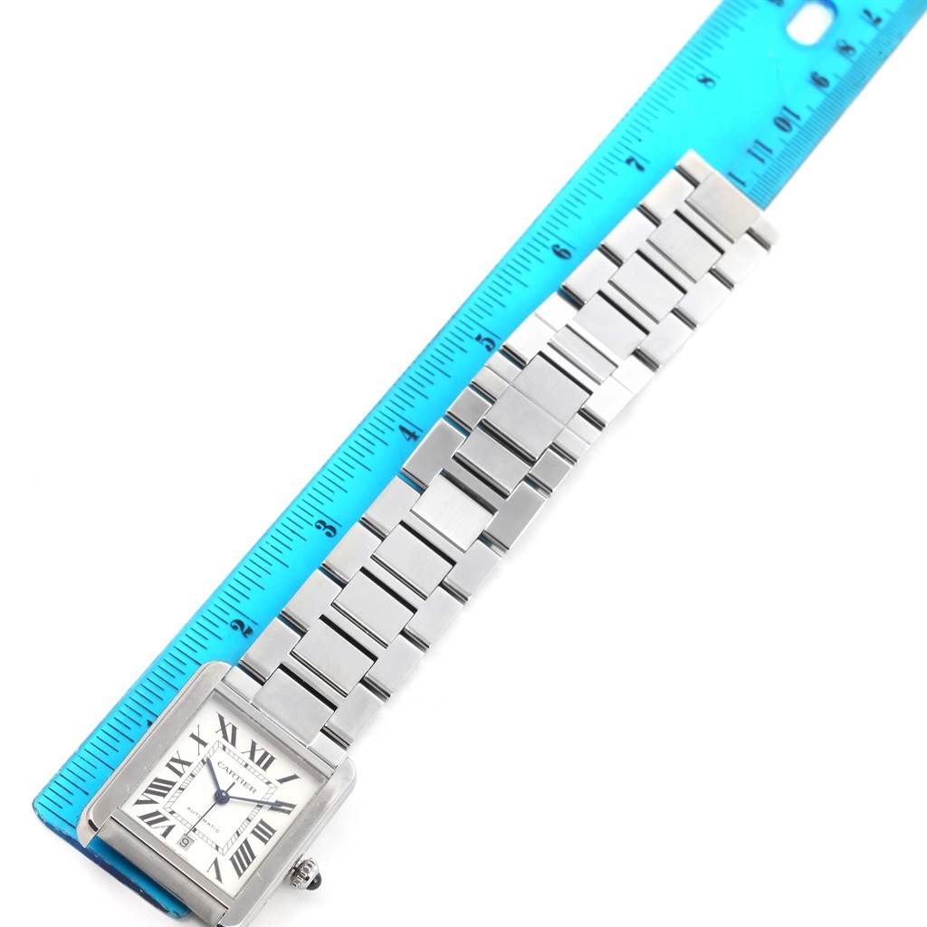 The Cartier Tank Solo W5200028 Men
s Stainless Steel Silver Dial W5200028 Men
s Stainless Steel Silver Dial watch is shown laid flat with its face and part of its bracelet, measured against a blue ruler.