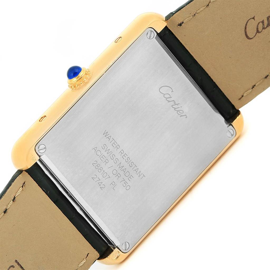 The image shows the back case and part of the leather strap of a Cartier Tank Solo W1018855 Men
s Steel and Gold (two tone) Silver Dial W1018855 Men
s Steel and Gold (two tone) Silver Dial watch.