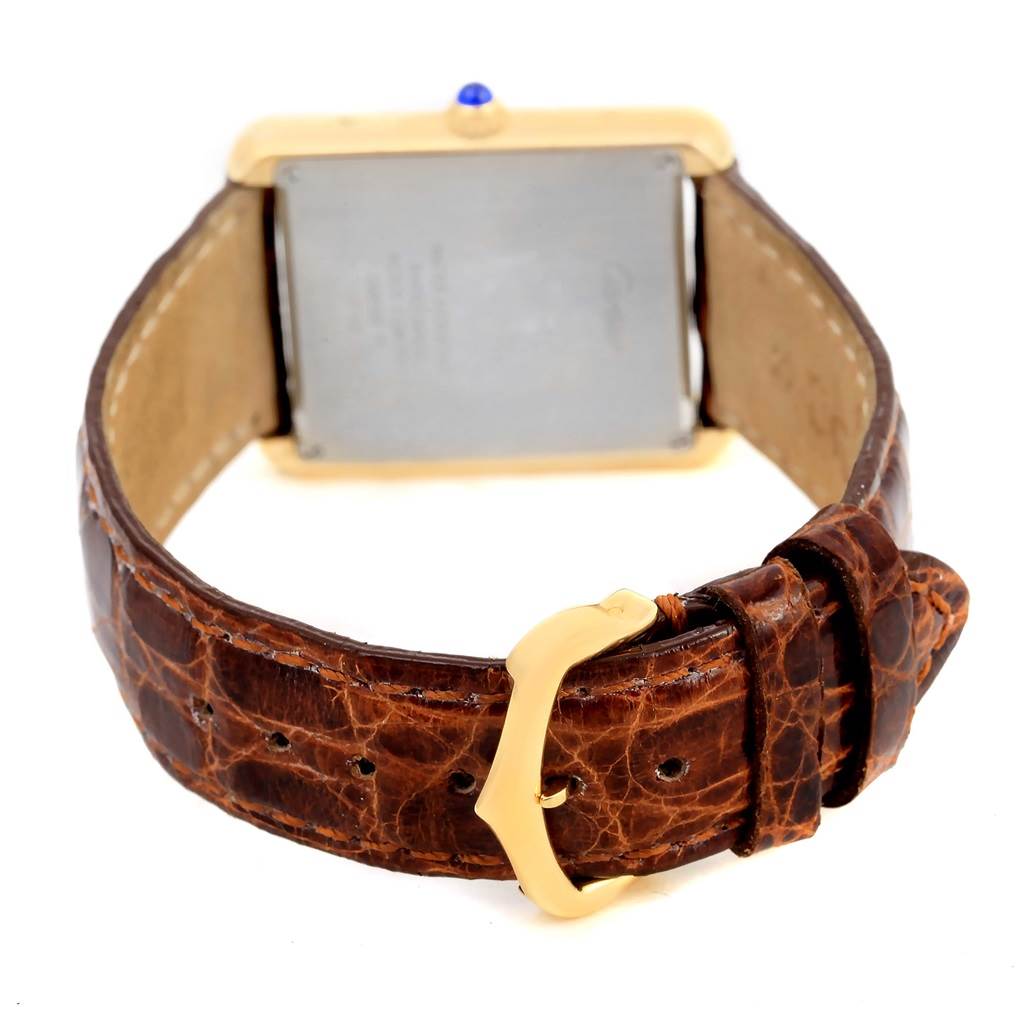 The image shows the back case and brown leather strap with a gold buckle of a Cartier Tank Solo W1018855 Men
s Steel and Gold (two tone) Silver Dial W1018855 Men
s Steel and Gold (two tone) Silver Dial watch.