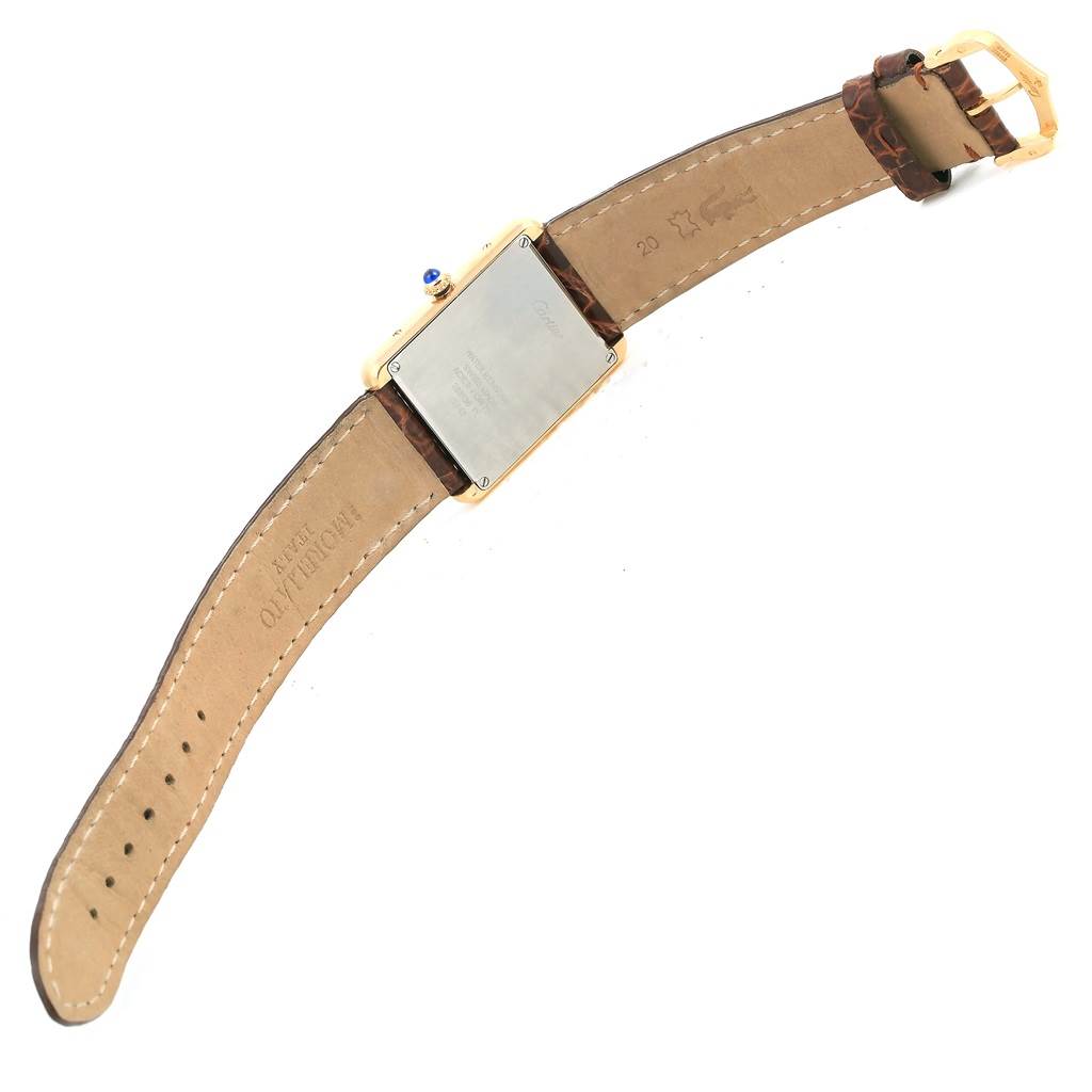 The Cartier Tank Solo W1018855 Men
s Steel and Gold (two tone) Silver Dial W1018855 Men
s Steel and Gold (two tone) Silver Dial watch is shown from the back, displaying its case back and leather strap in an open position.