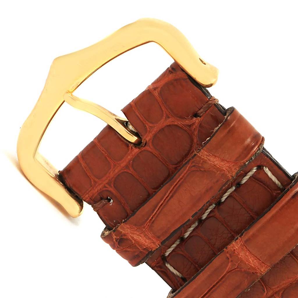 The image shows a close-up of the brown leather strap and gold buckle of a Cartier Tank Solo W1018855 Men
s Steel and Gold (two tone) Silver Dial W1018855 Men
s Steel and Gold (two tone) Silver Dial model watch.