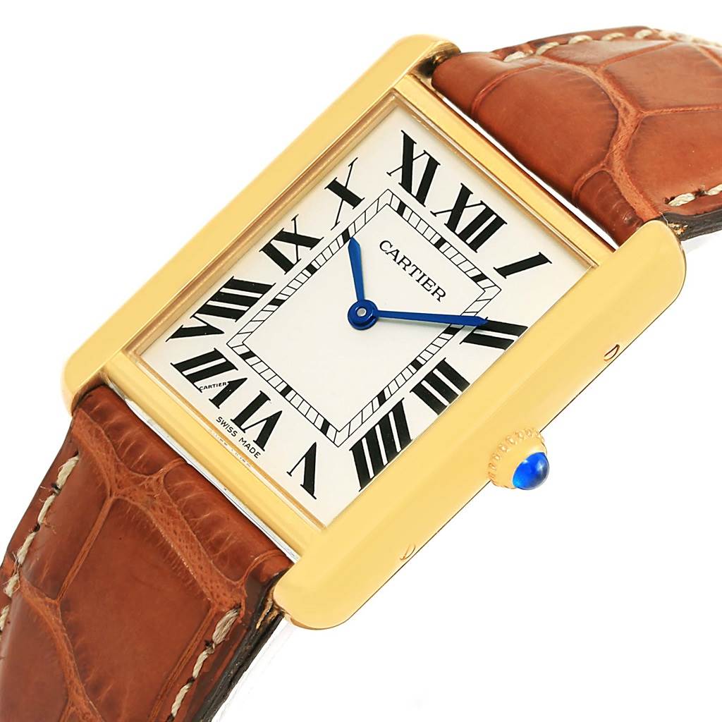 The image shows a Cartier Tank Solo W1018855 Men
s Steel and Gold (two tone) Silver Dial W1018855 Men
s Steel and Gold (two tone) Silver Dial watch at an angled view, highlighting the watch face, strap, and crown with a blue cabochon.
