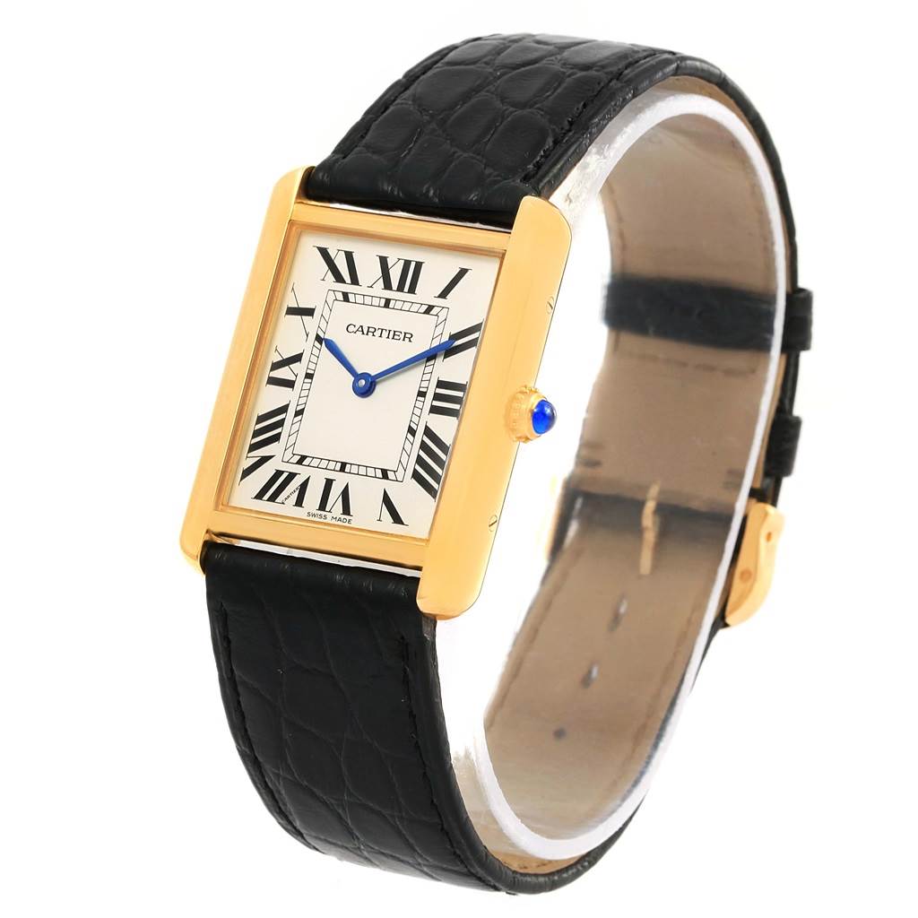 The image shows a Tank Solo model by Cartier from an oblique angle, highlighting the face, leather strap, and crown with a blue cabochon.