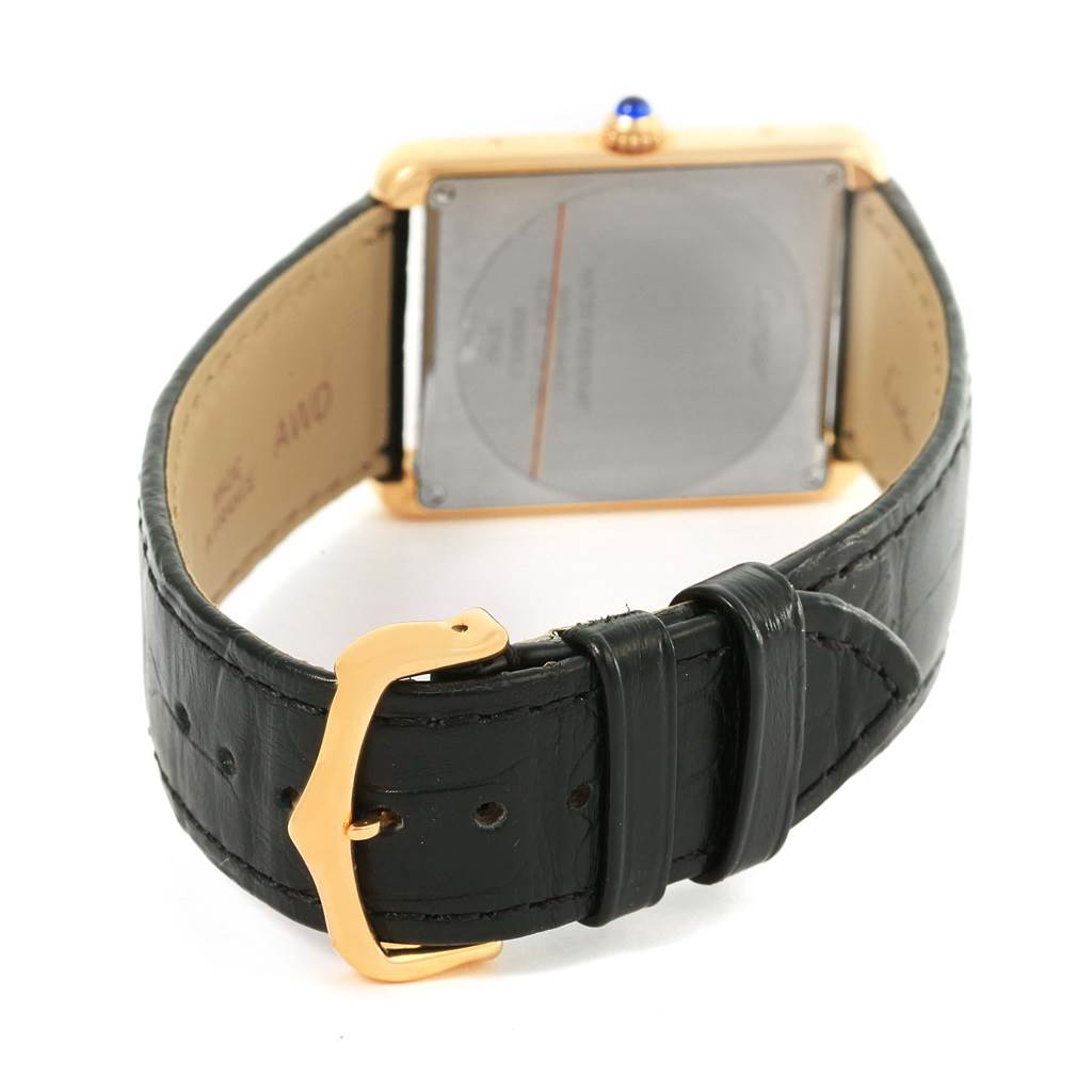 The image shows the back of the Cartier Tank Solo W1018855 Steel and Gold (two tone) Silver Dial W1018855 Steel and Gold (two tone) Silver Dial watch and part of its black leather strap with a gold buckle.