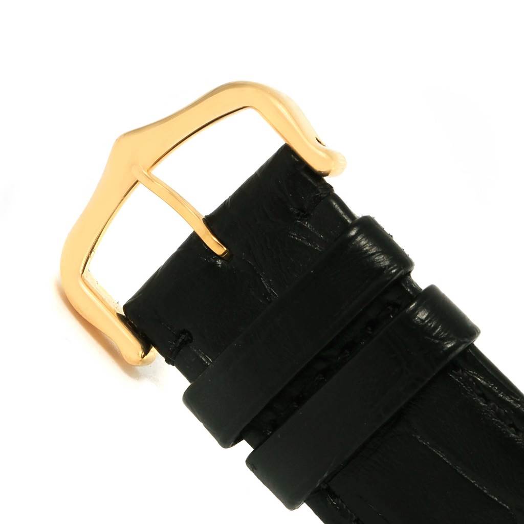 This image shows a close-up of the black leather strap and gold buckle of a Tank Solo model watch by Cartier.