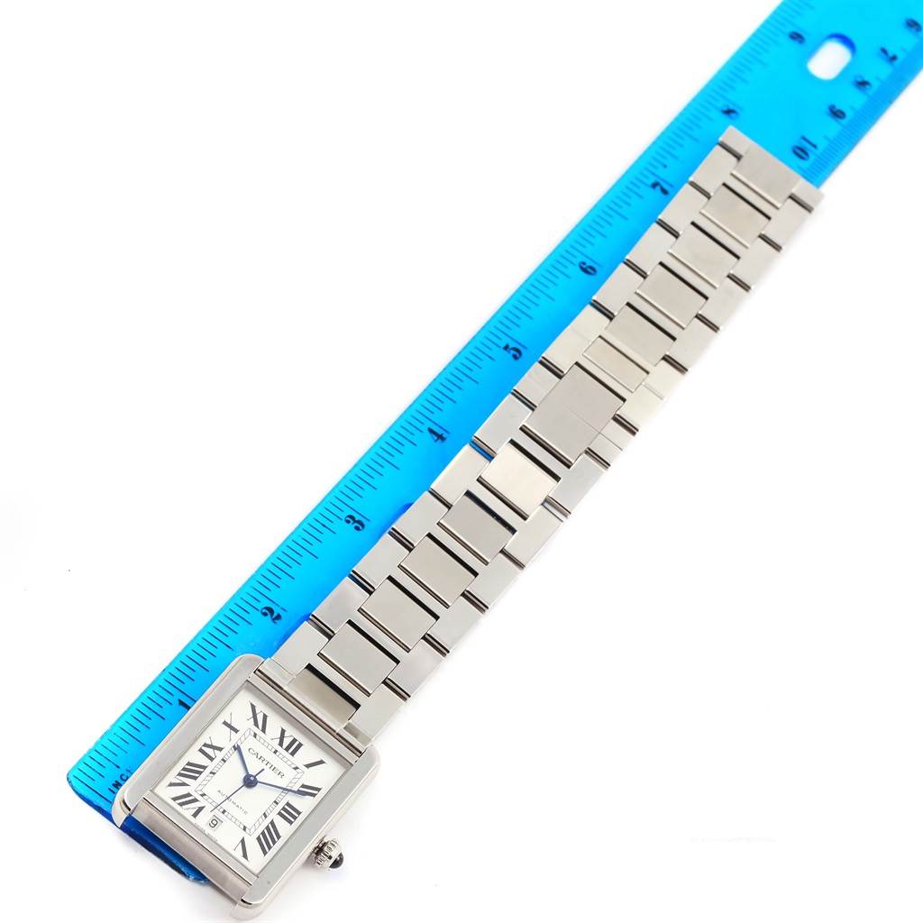 The image shows a Cartier Tank Solo W5200028 Men
s Stainless Steel Silver Dial W5200028 Men
s Stainless Steel Silver Dial watch laid flat beside a ruler, displaying its face and metal bracelet.