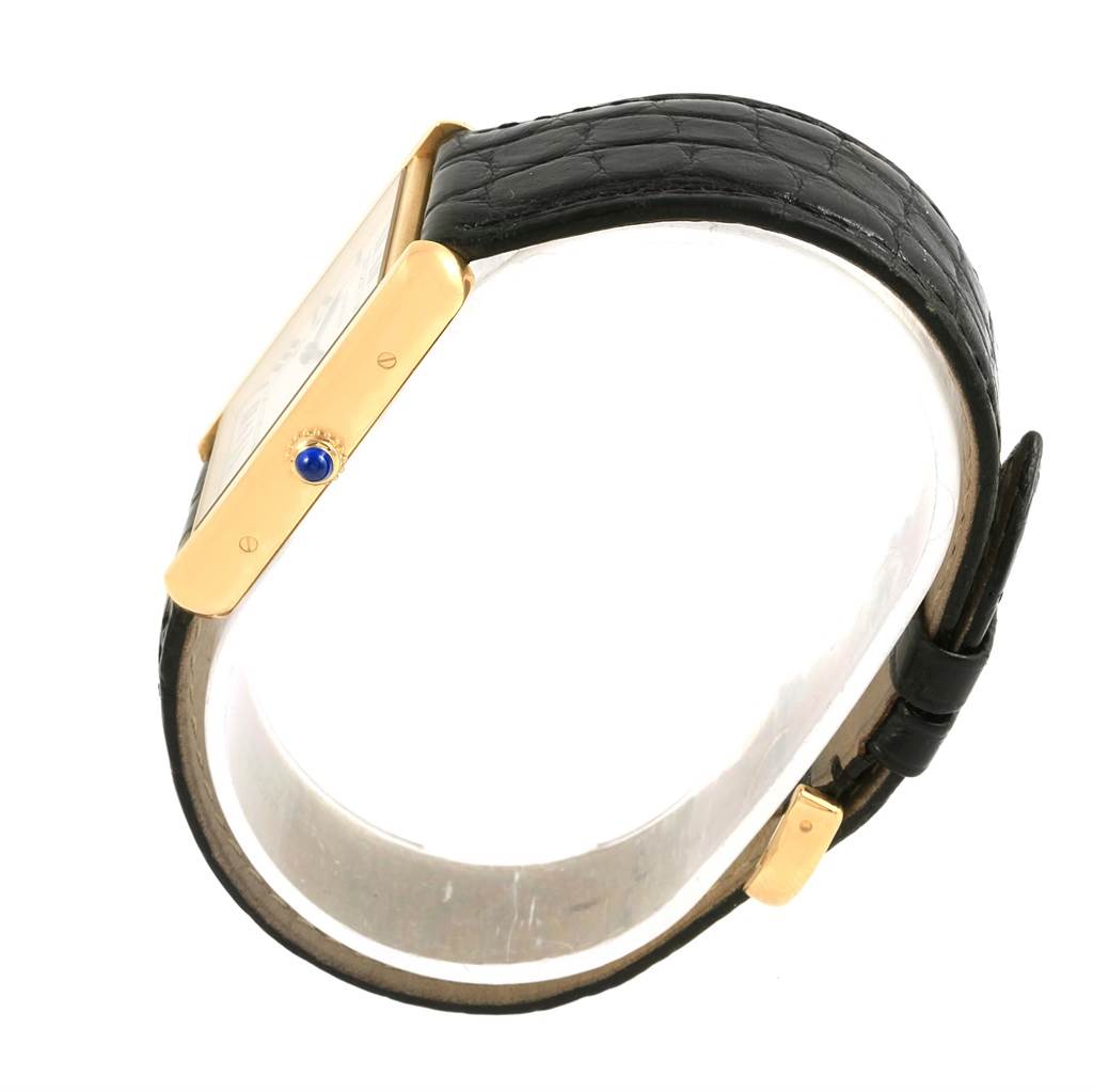 The Cartier Tank Solo W1018855 Steel and Gold (two tone) Silver Dial W1018855 Steel and Gold (two tone) Silver Dial watch is shown from a side angle, highlighting its gold case, blue jewel crown, and black leather strap.