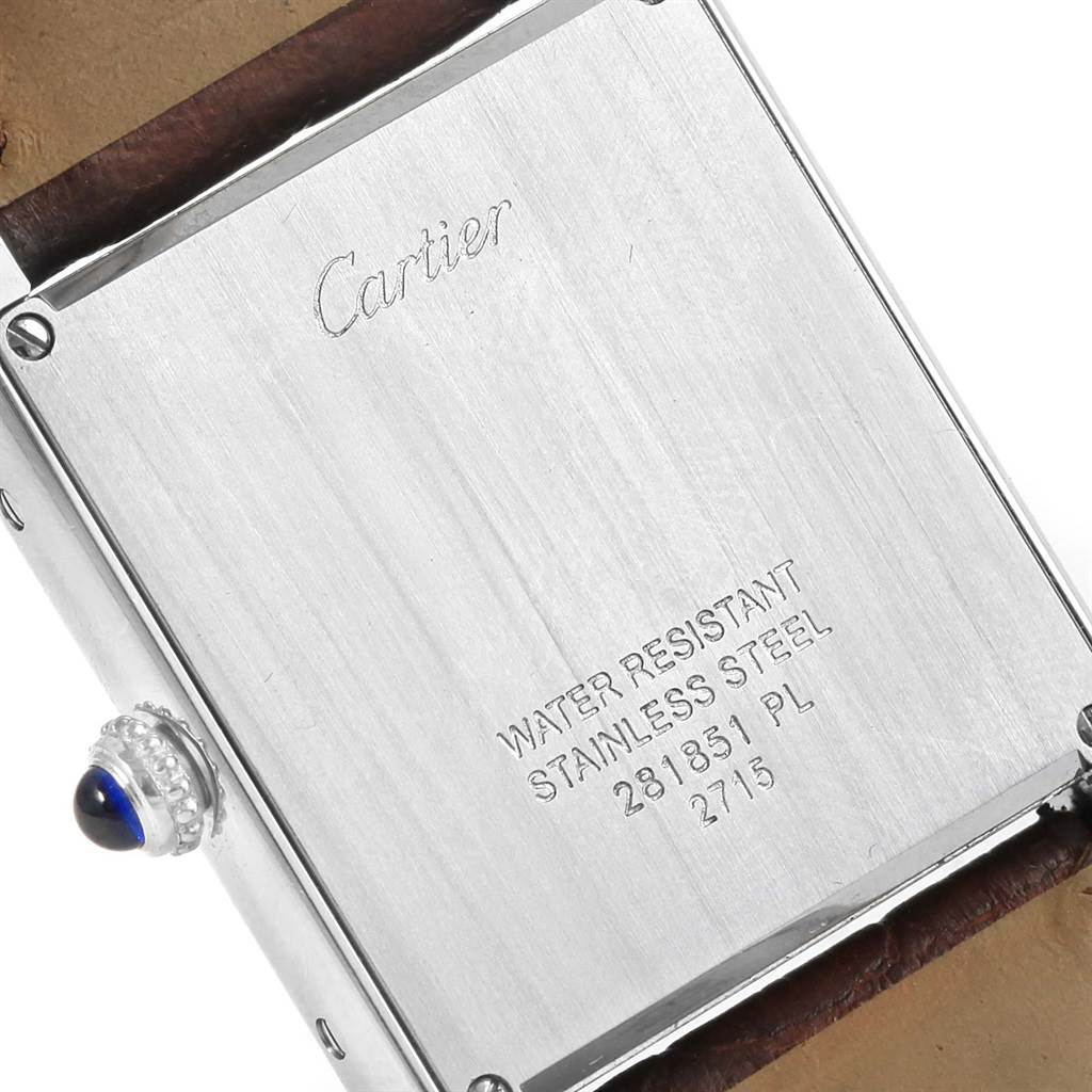 The image shows the back case of the Cartier Tank Solo W1018355 Stainless Steel Silver Dial W1018355 Stainless Steel Silver Dial watch, featuring engravings and the crown with a blue cabochon.