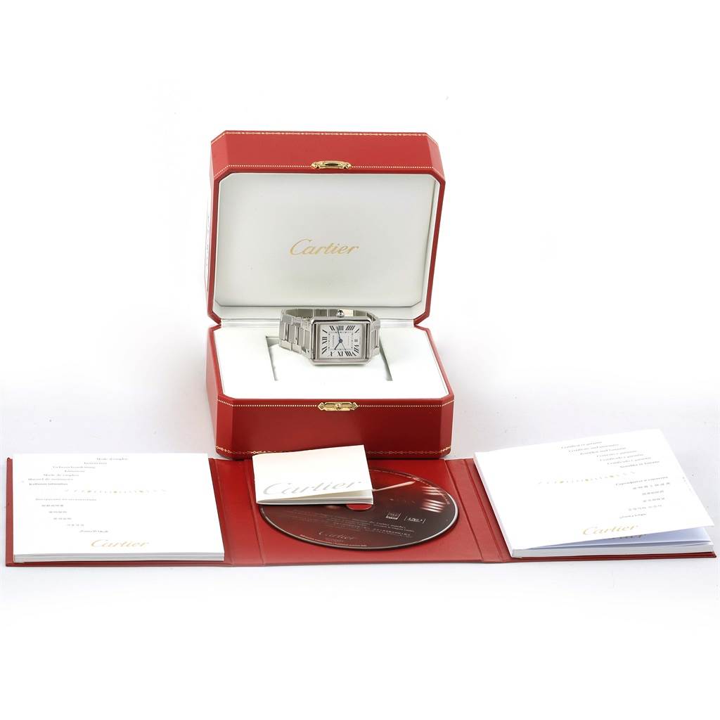 The image shows a Cartier Tank Solo W5200028 Men
s Stainless Steel Silver Dial W5200028 Men
s Stainless Steel Silver Dial watch in its box, accompanied by documentation and a CD.