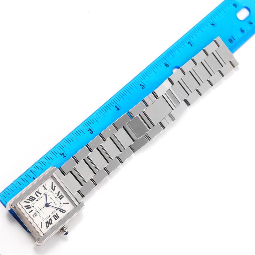 The image shows the Cartier Tank Solo W5200028 Men
s Stainless Steel Silver Dial W5200028 Men
s Stainless Steel Silver Dial watch at an oblique angle with its metal bracelet laid next to a ruler for scale.