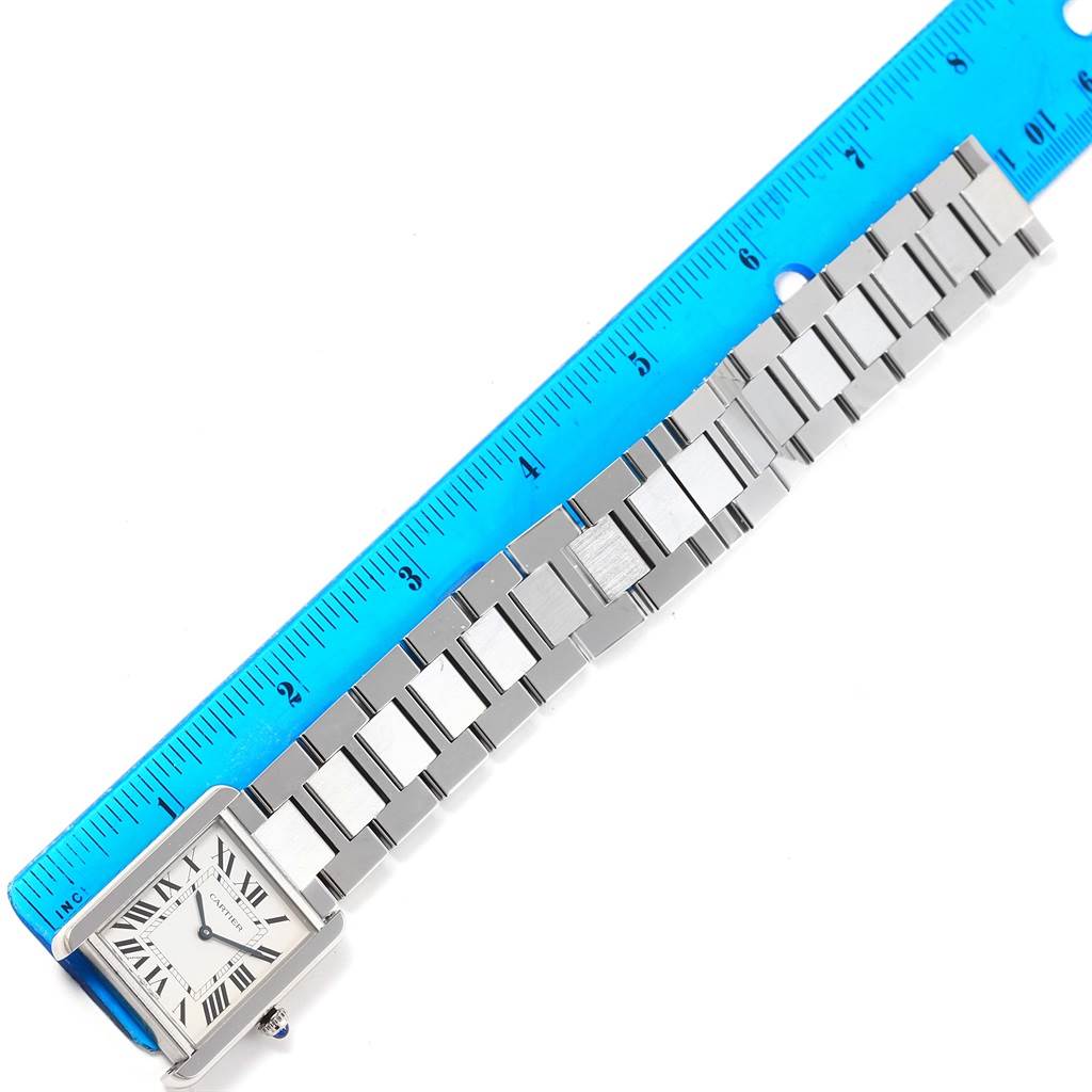 The image shows a Cartier Tank Solo W5200014 Stainless Steel Silver Dial W5200014 Stainless Steel Silver Dial watch with a metal bracelet, placed next to a blue ruler for size reference.