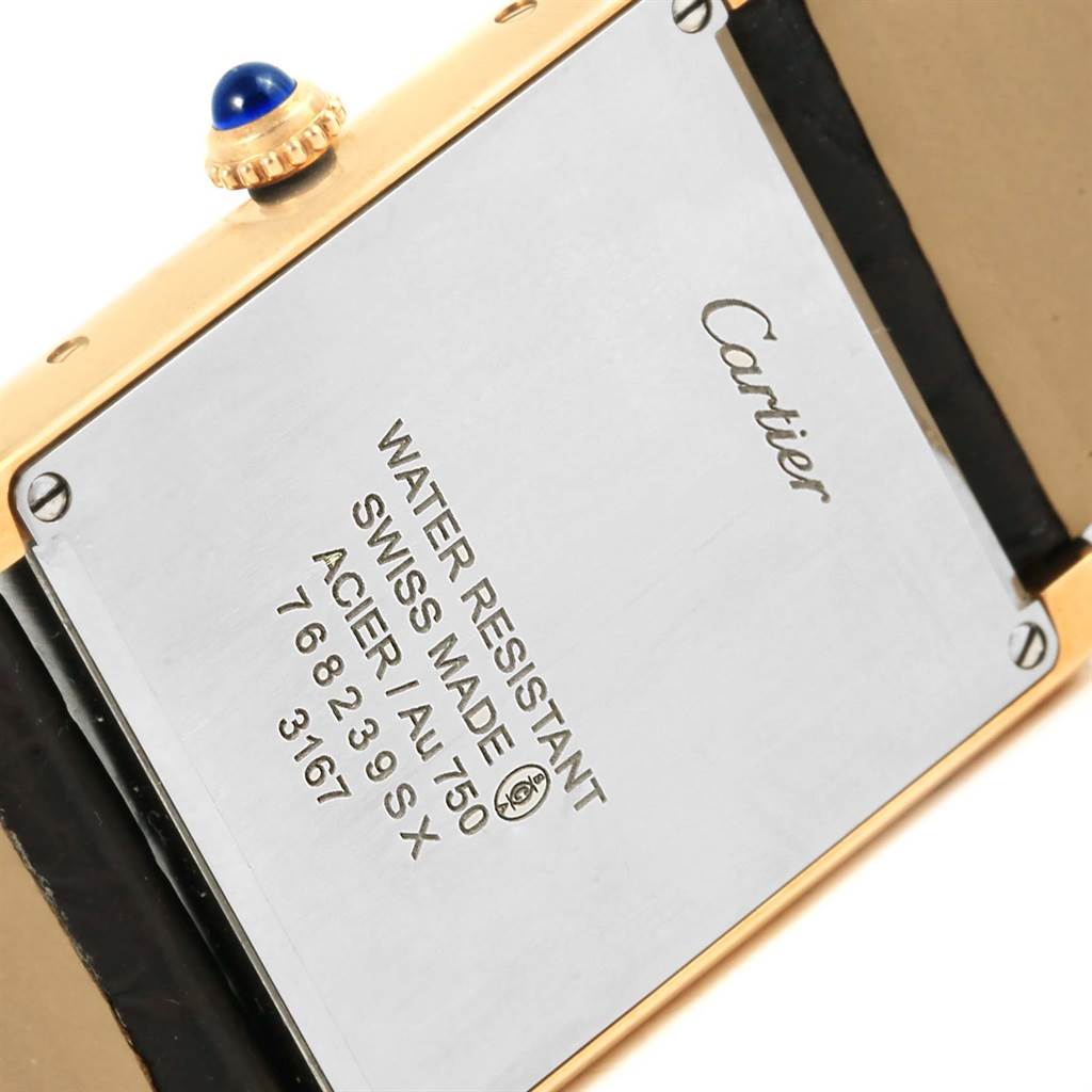 The image shows the back case of a Cartier Tank Solo W1018855 Steel and Gold (two tone) Silver Dial W1018855 Steel and Gold (two tone) Silver Dial watch, highlighting its inscriptions and a crown with a blue gemstone.