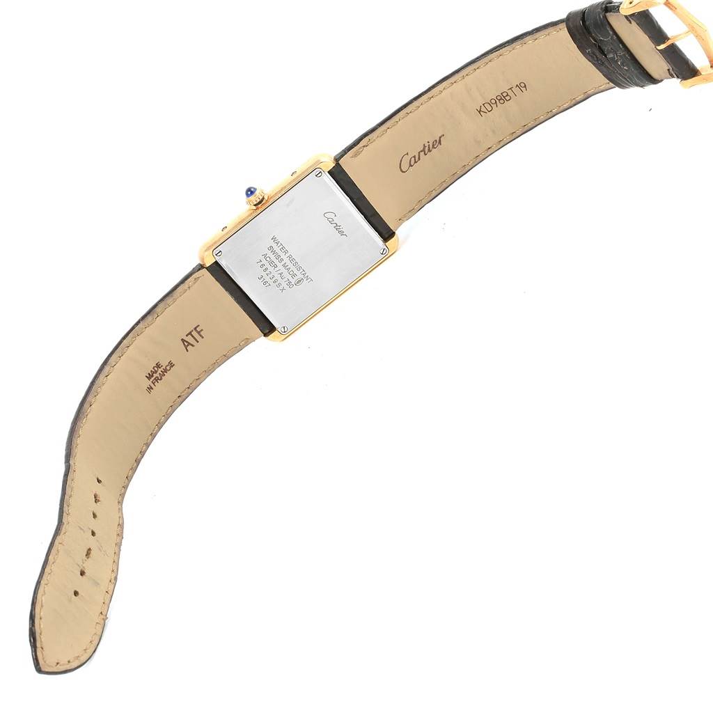 The image shows the back side of a Cartier Tank Solo W1018855 Steel and Gold (two tone) Silver Dial W1018855 Steel and Gold (two tone) Silver Dial watch, including its leather strap and markings.
